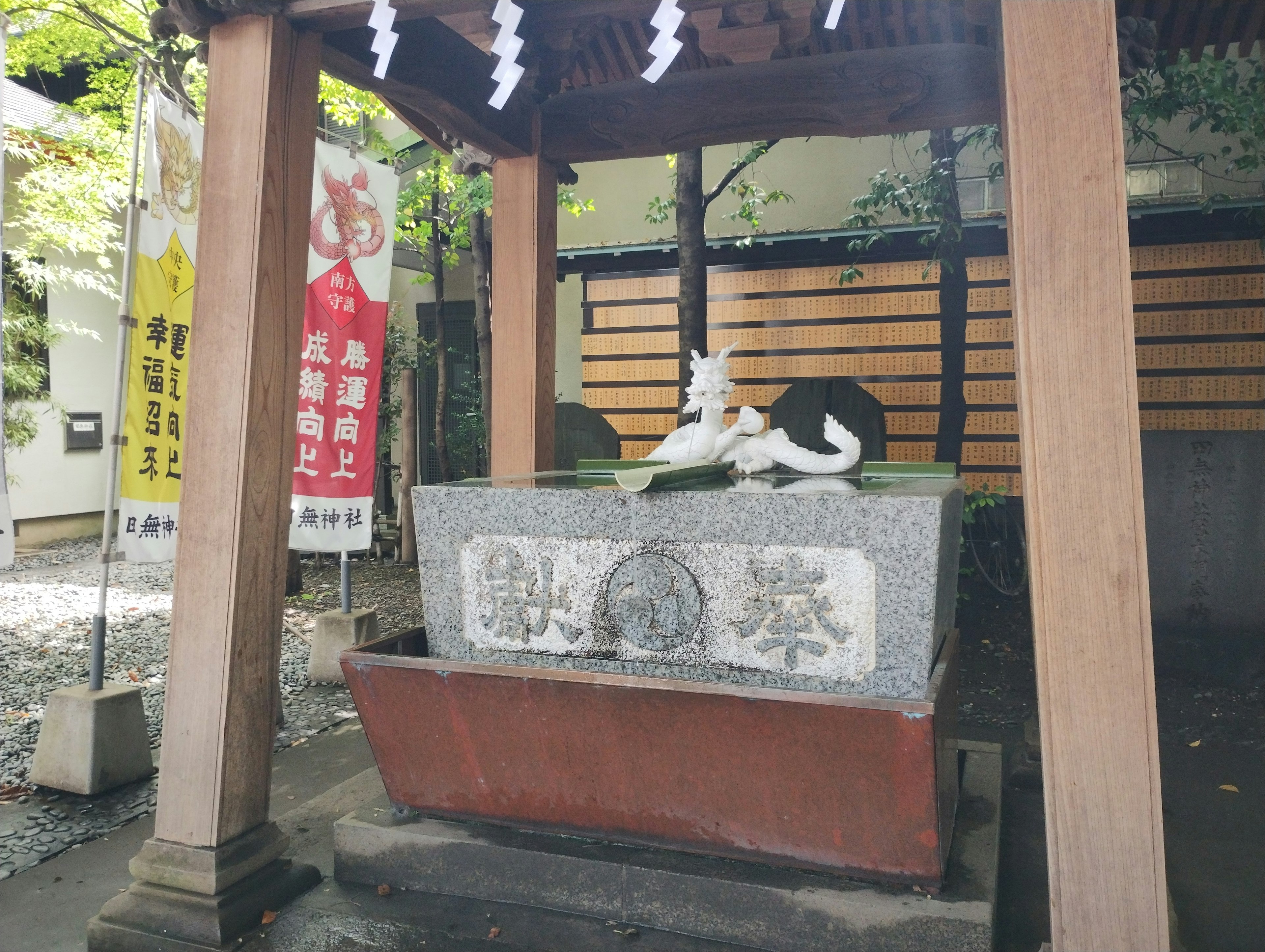 神社の水場にある石の洗い場と白い狐の像