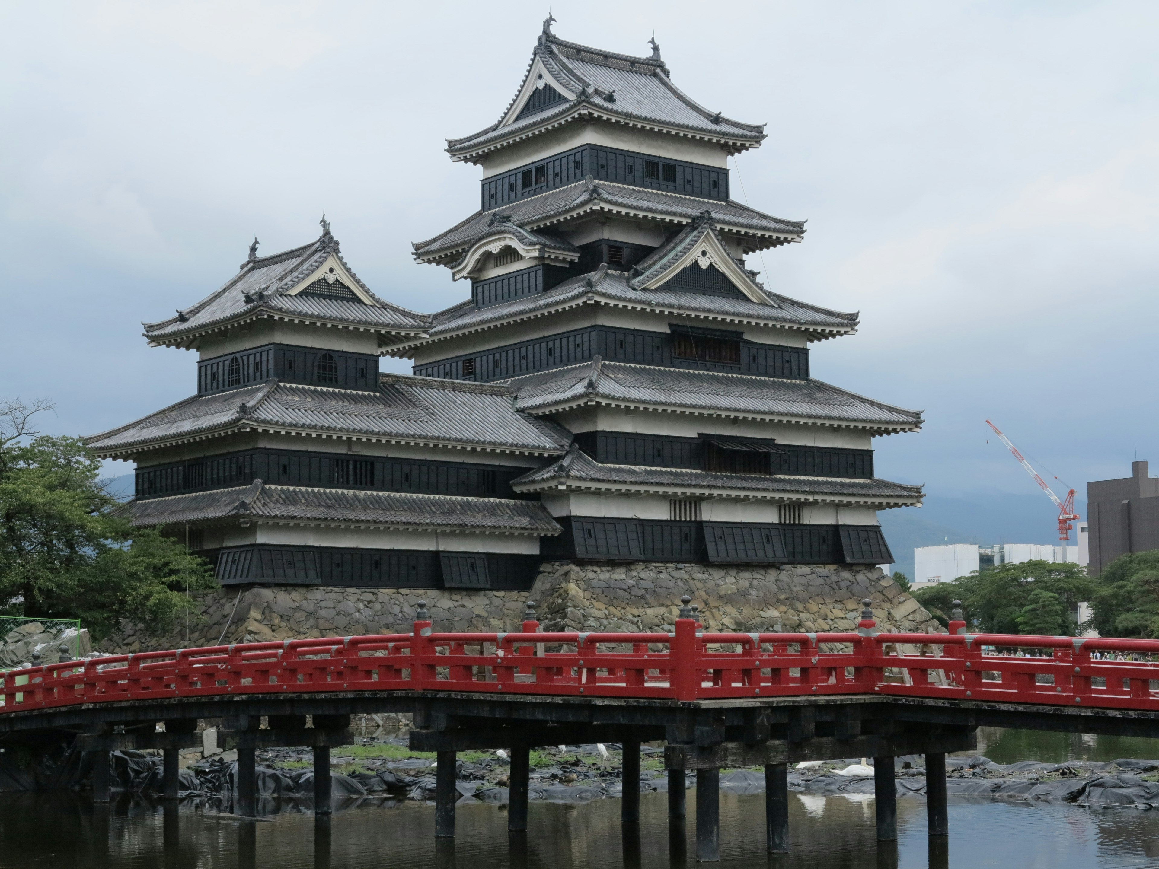 Hermosa fachada del castillo de Matsumoto con un puente rojo