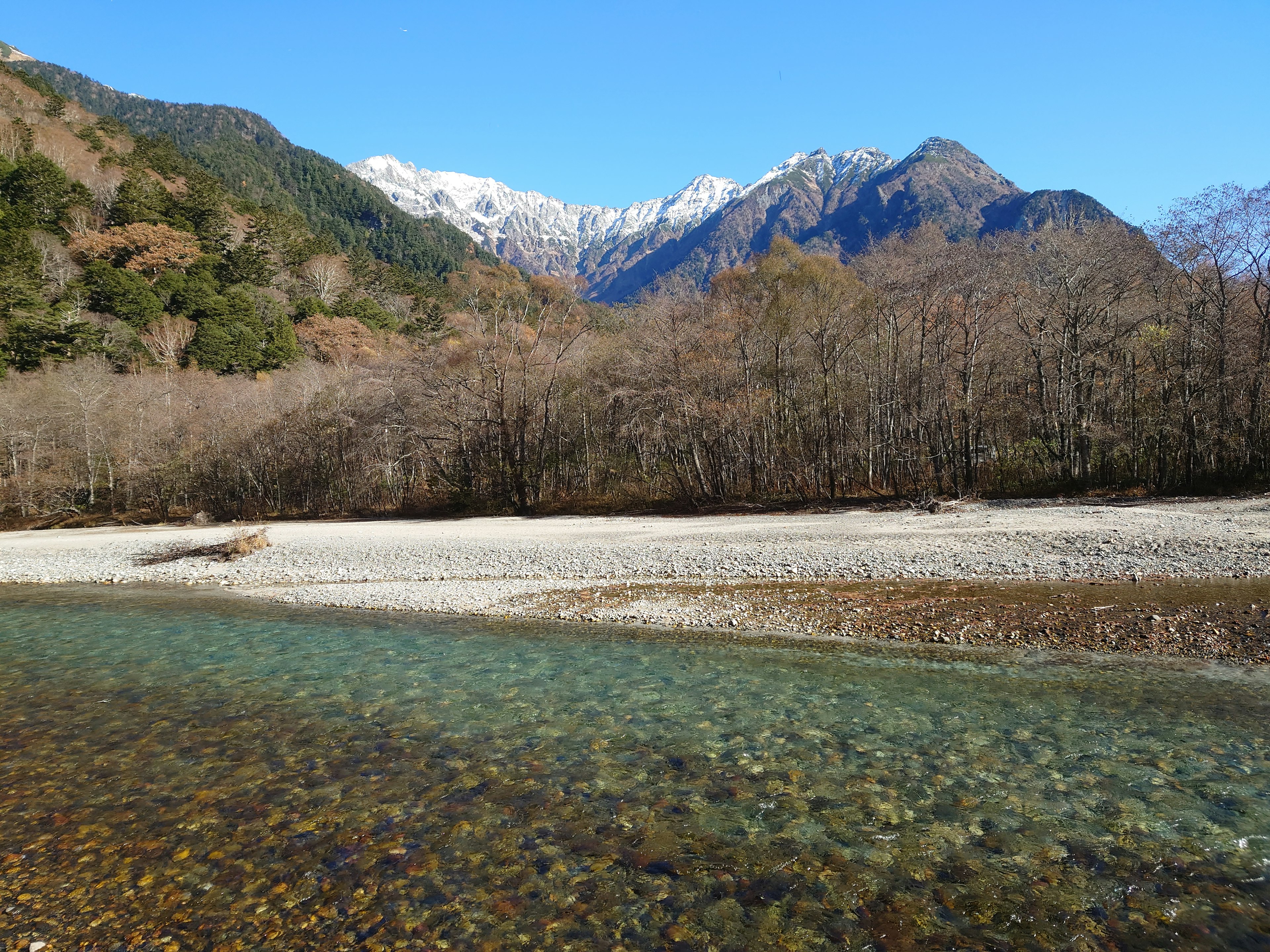 Rivière claire avec des montagnes enneigées en arrière-plan