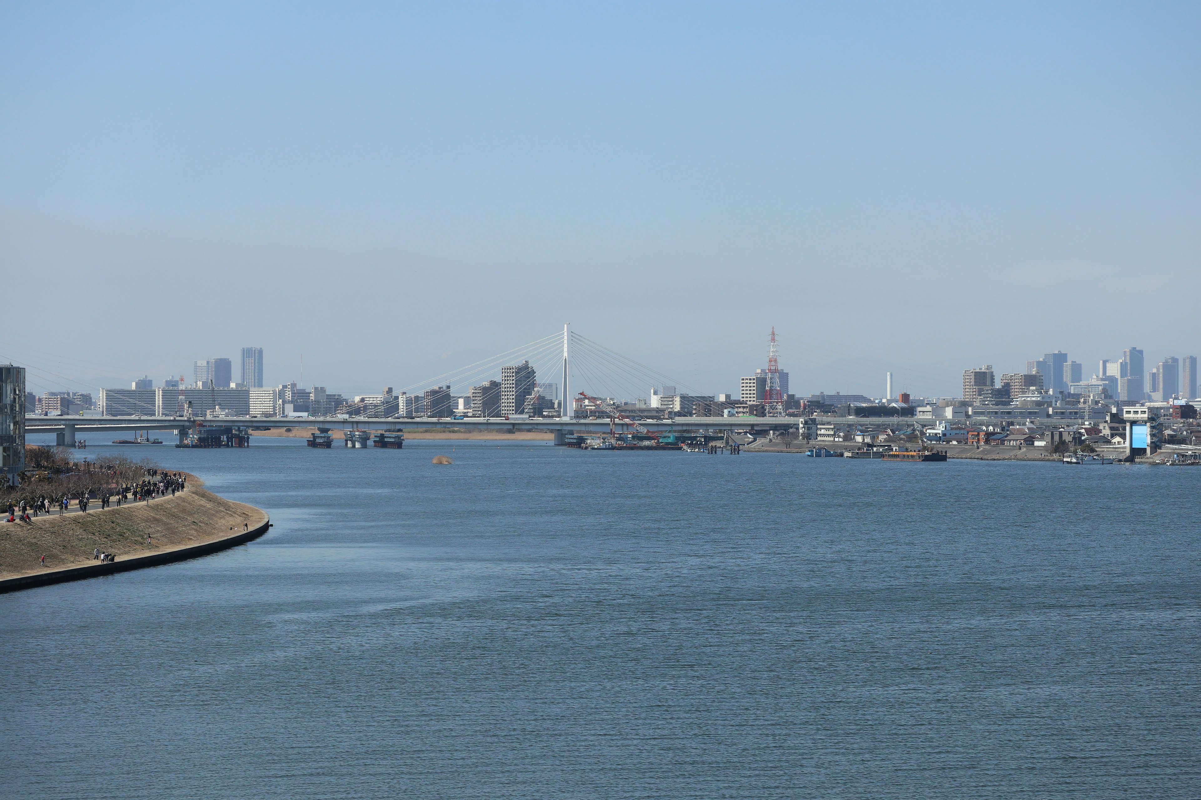 Panoramic view of a river and city skyline under a clear blue sky