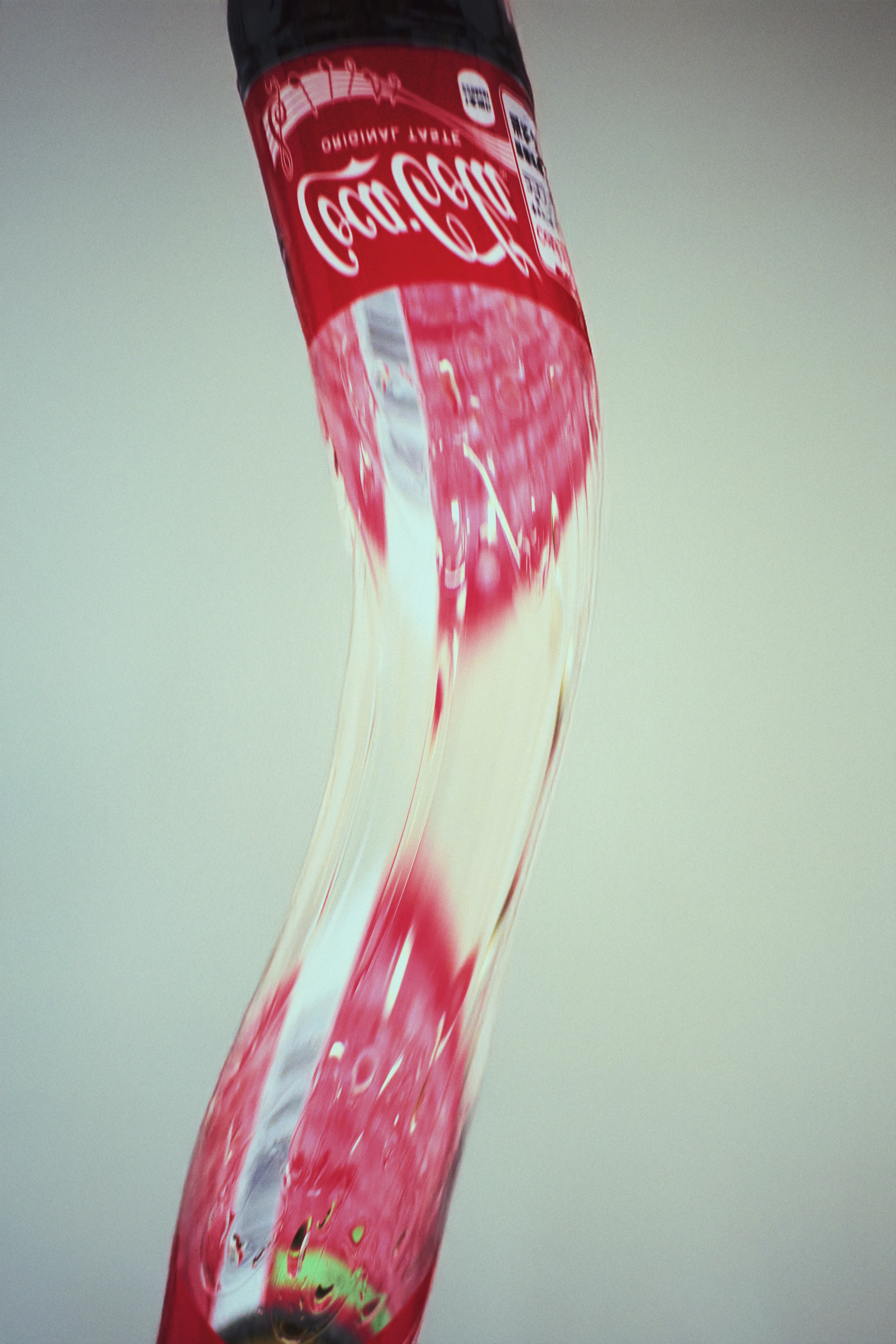 Una bottiglia di Coca-Cola distorta su uno sfondo bianco