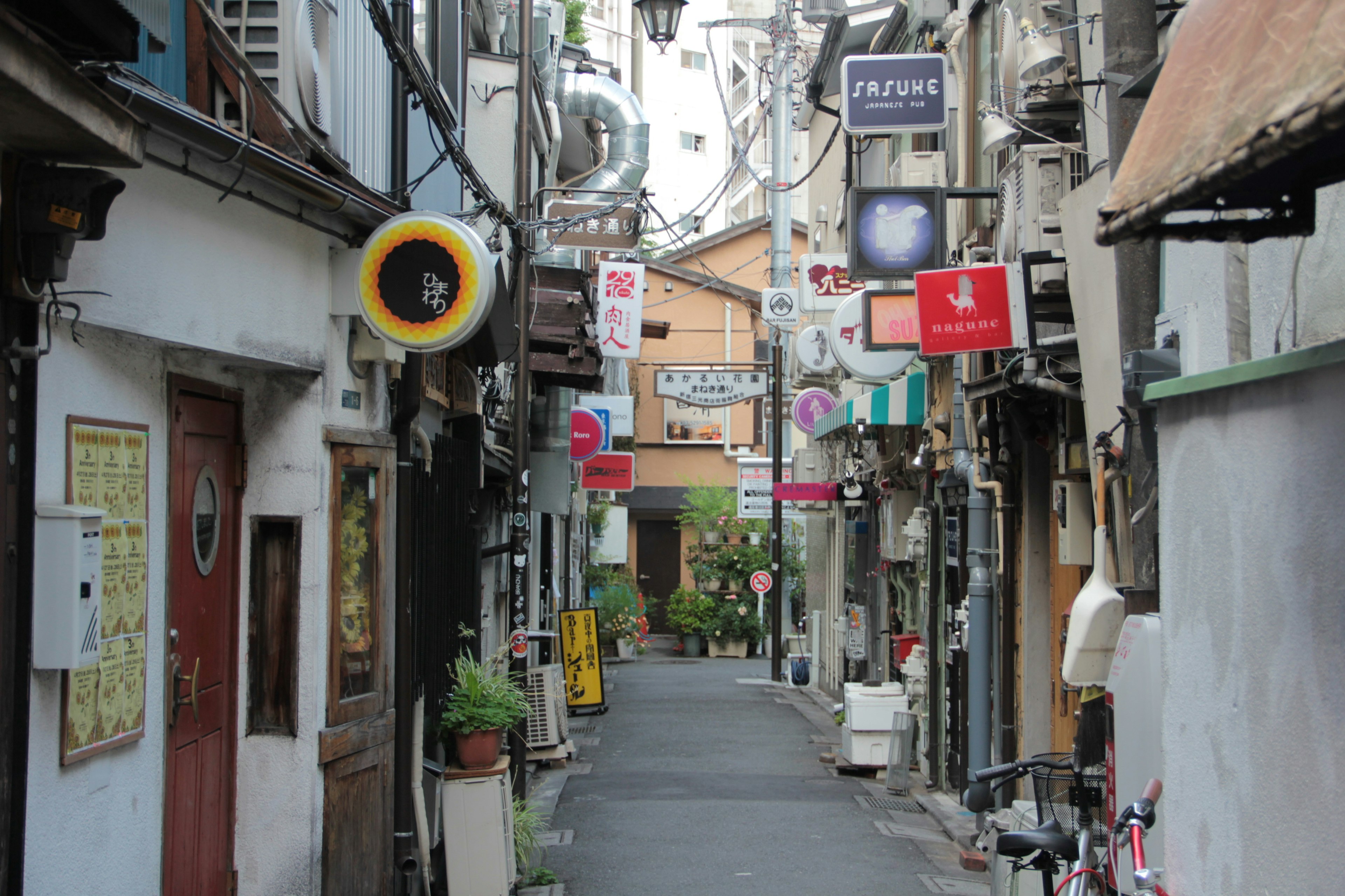 Lorong sempit dengan toko dan tanda warna-warni