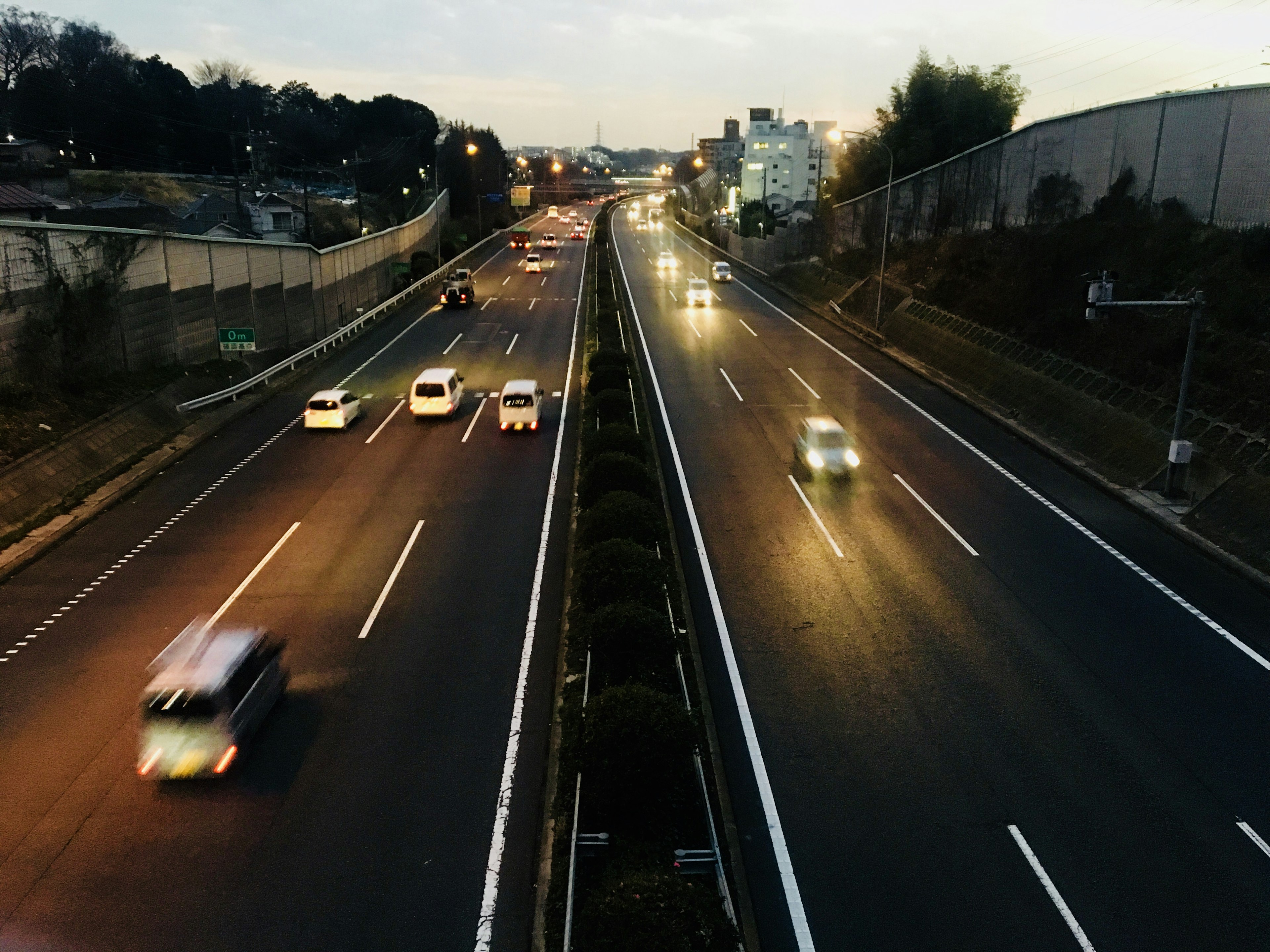 Nighttime view of a highway with moving cars and city lights