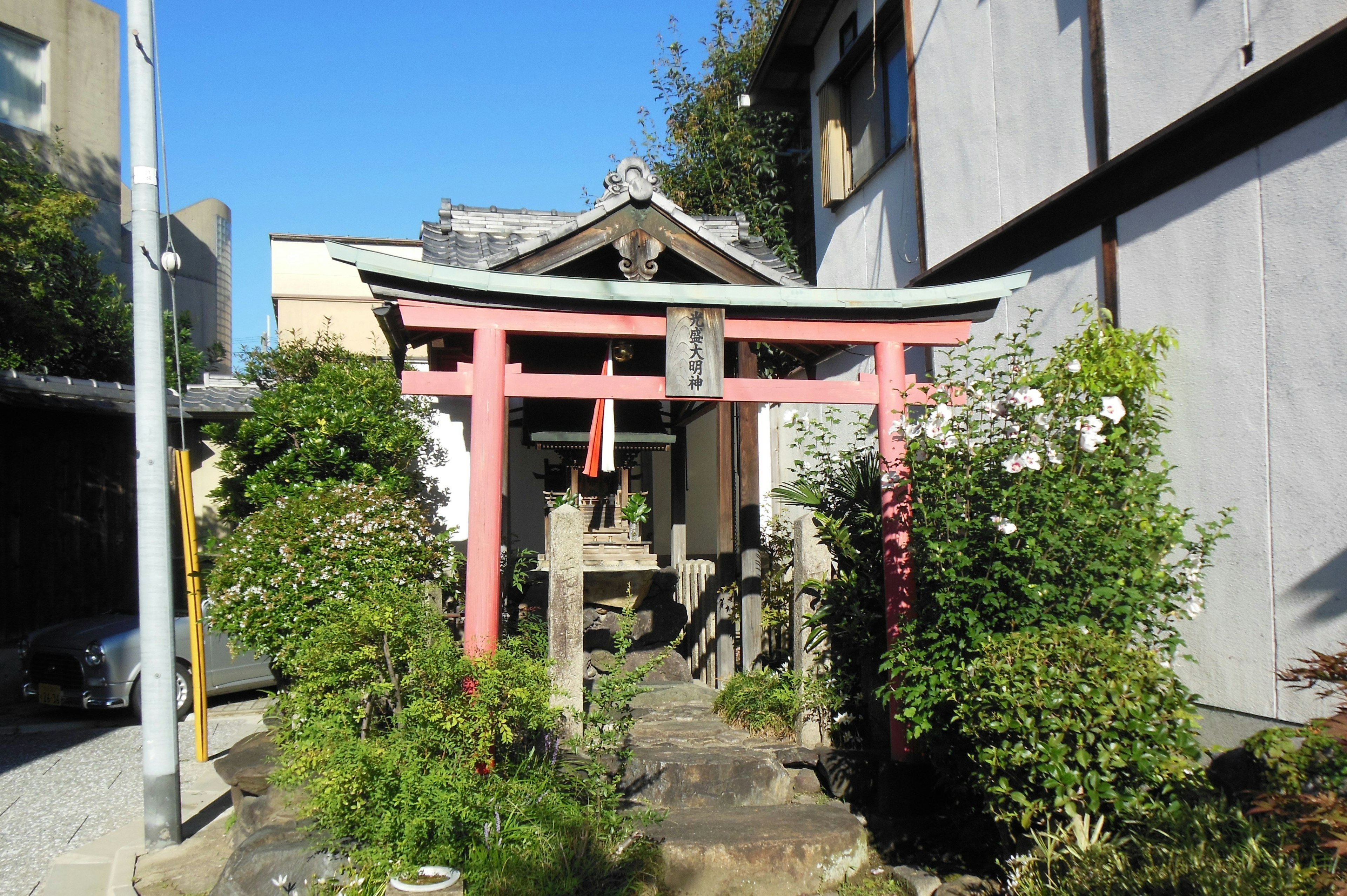 神社入口，红色鸟居和郁郁葱葱的绿植