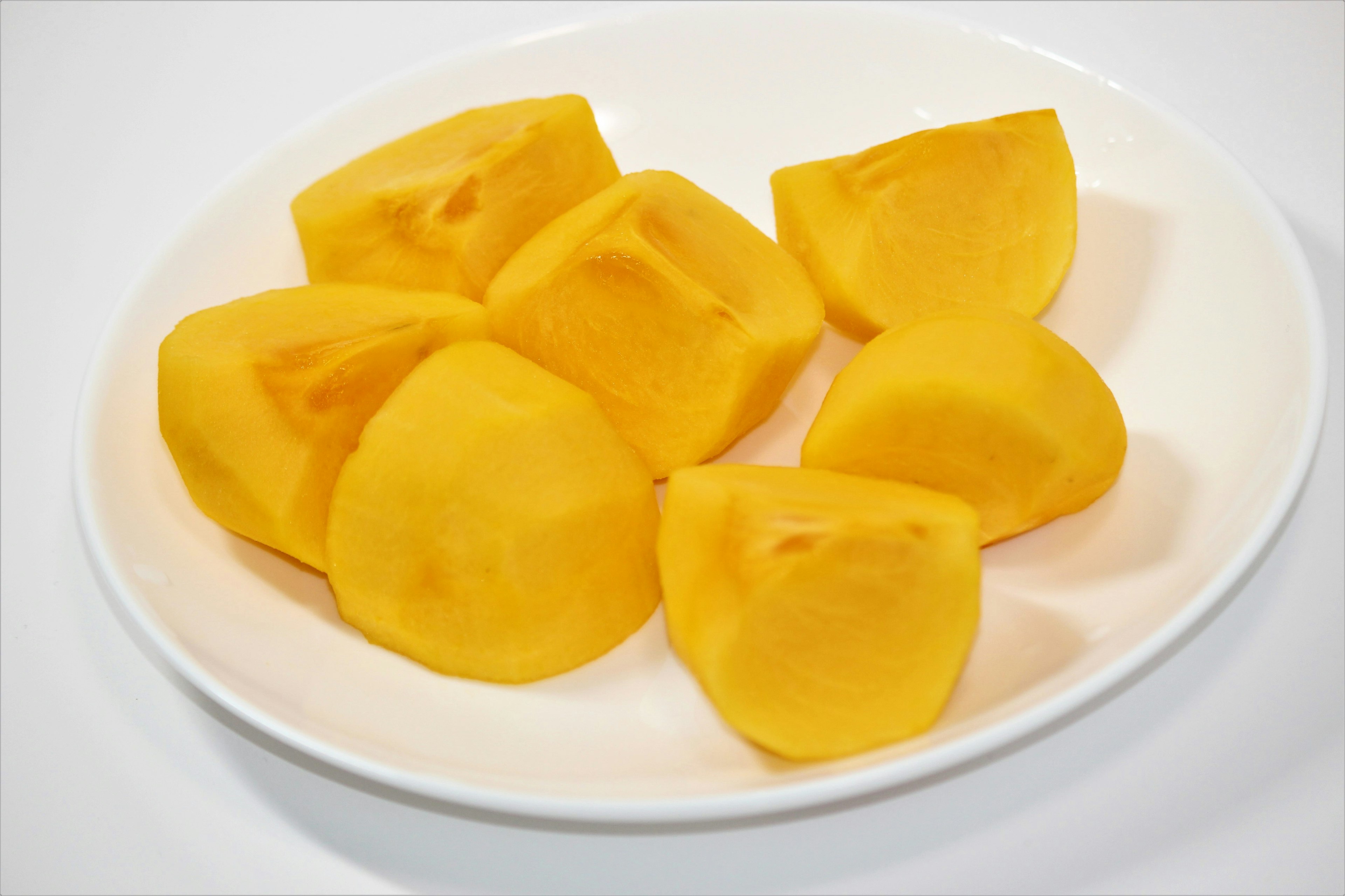 Potongan mangga kuning di atas piring putih