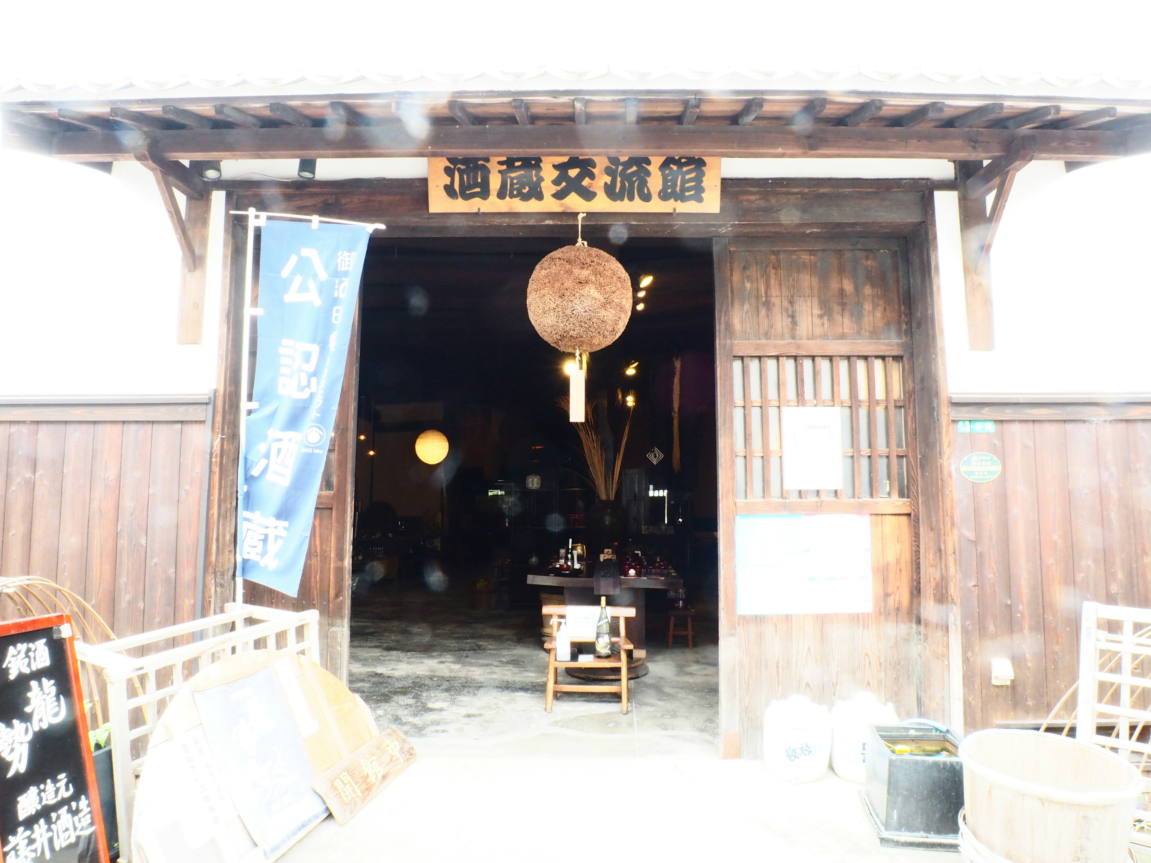 Entrance of a traditional wooden building with a sign and lantern