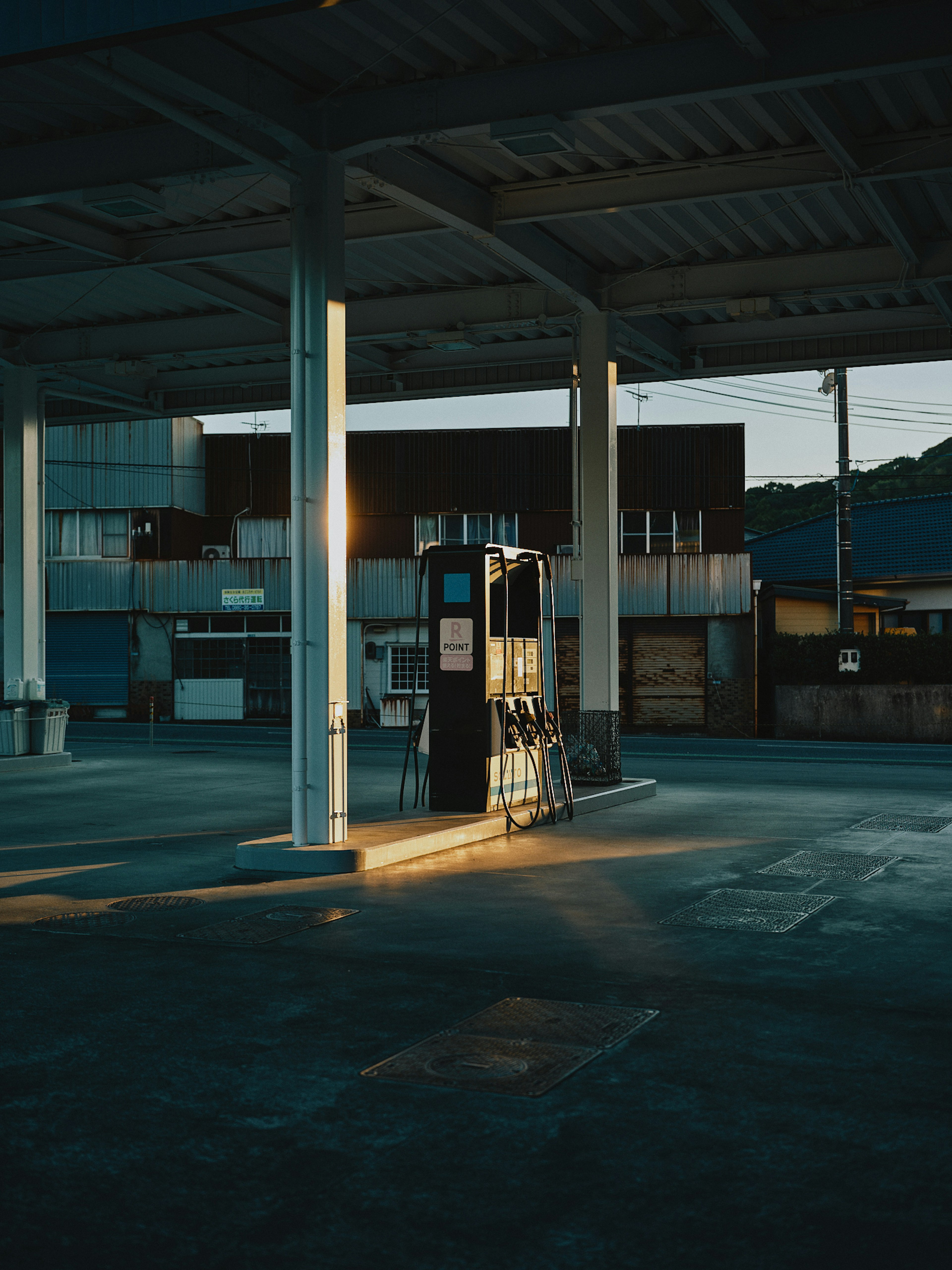 Pompa di benzina debolmente illuminata con ombre circostanti