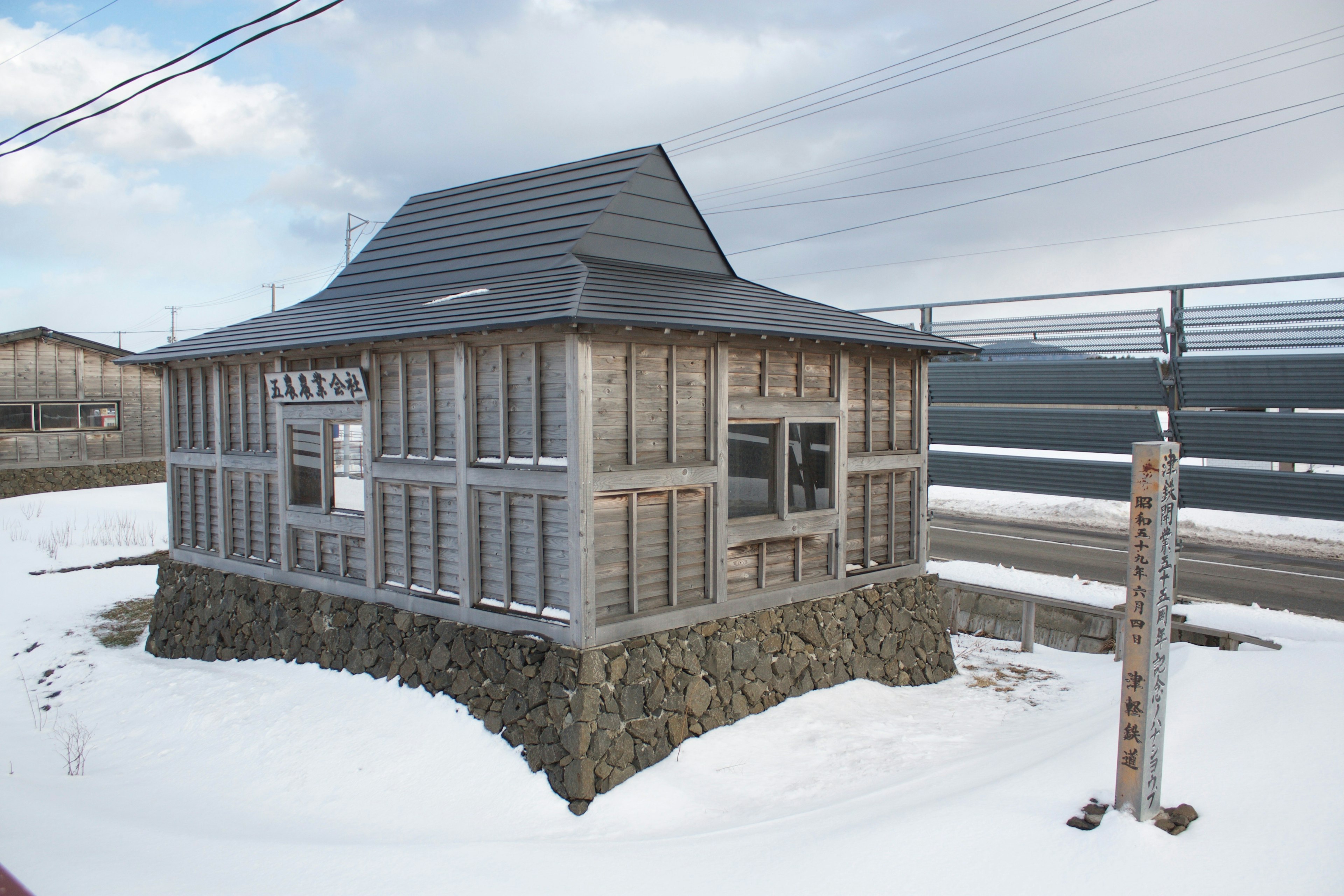 雪に覆われた小さな木造の家屋とその周囲の風景