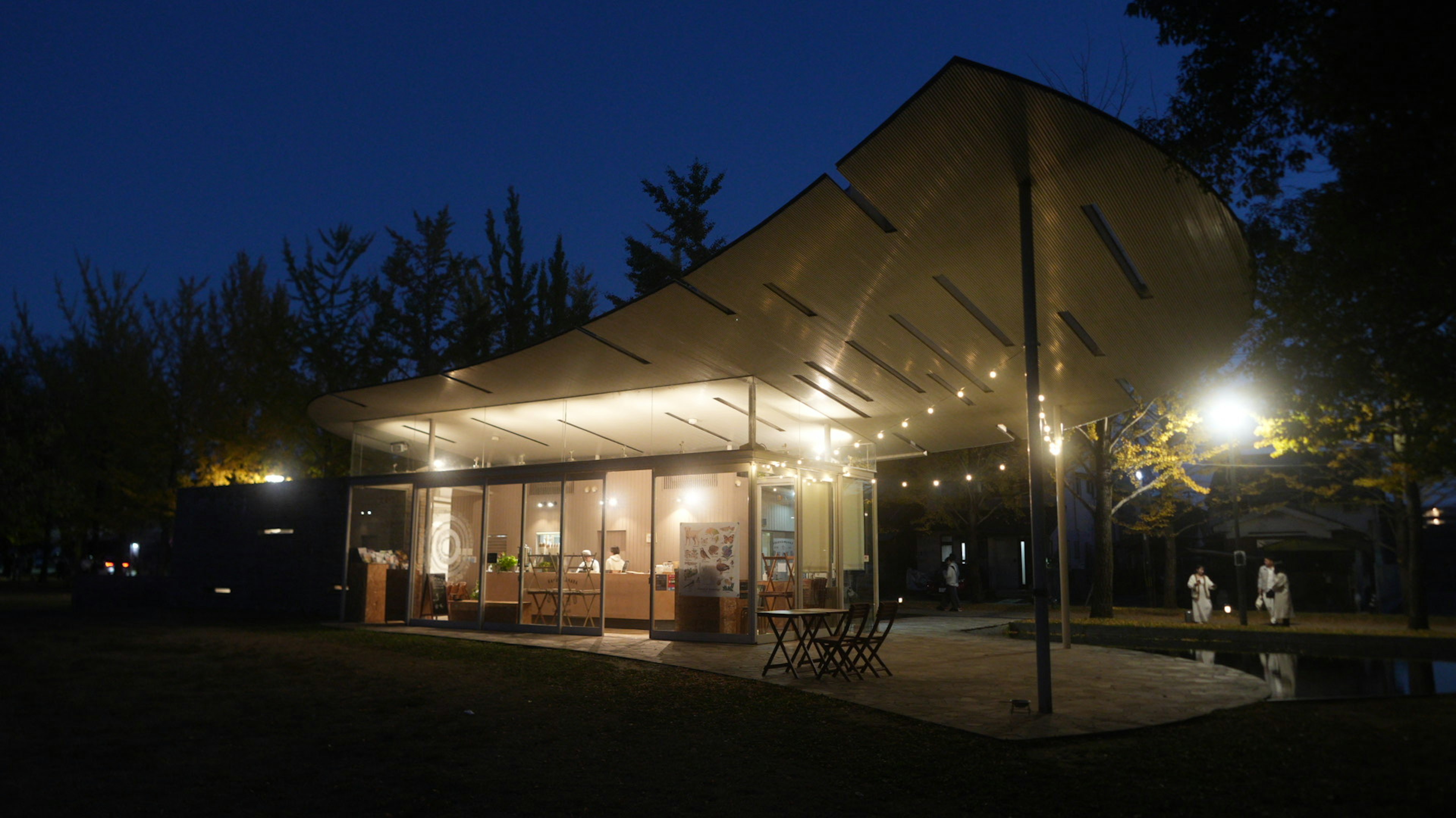 Modernes Café mit Außenbeleuchtung in einem Park bei Nacht