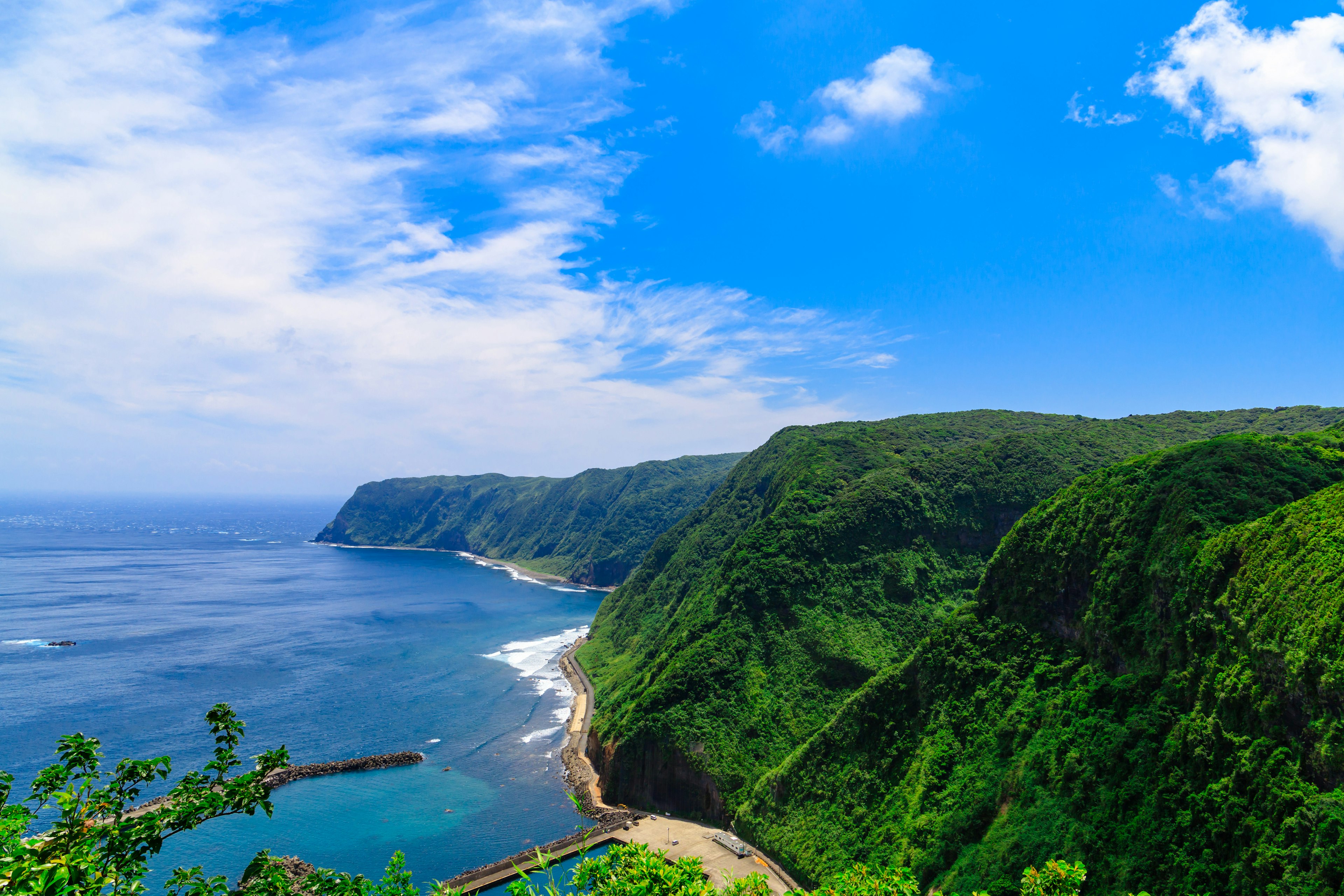 Beautiful coastline featuring blue ocean and lush green mountains