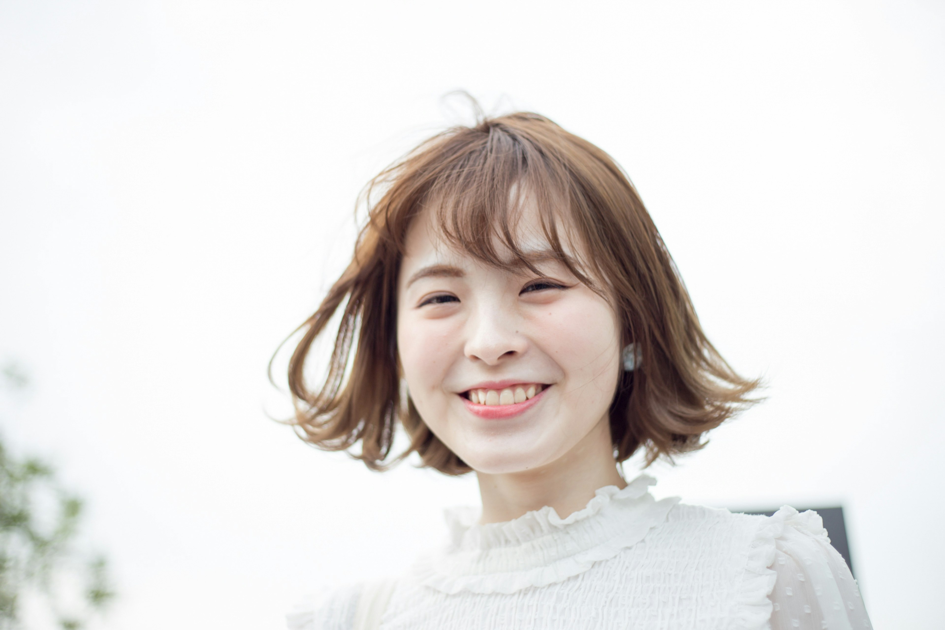 Portrait of a young woman smiling in front of a white background