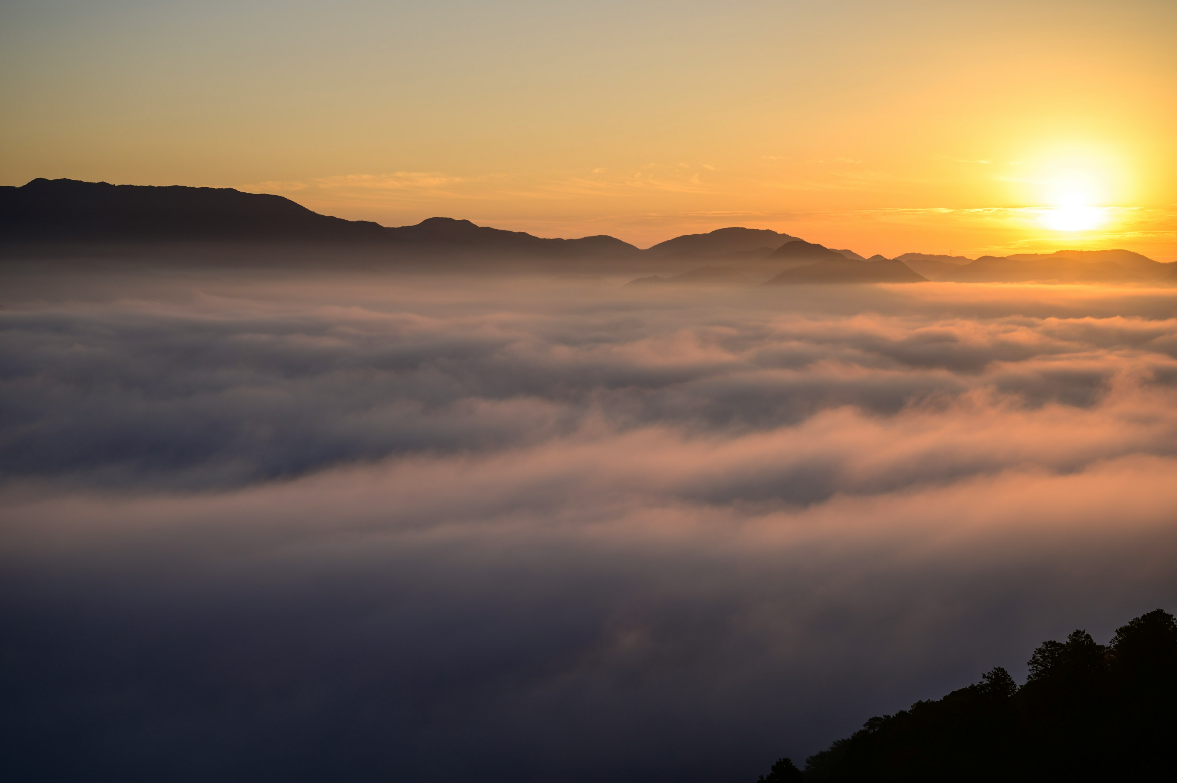 Stupenda alba su un mare di nuvole con montagne sullo sfondo