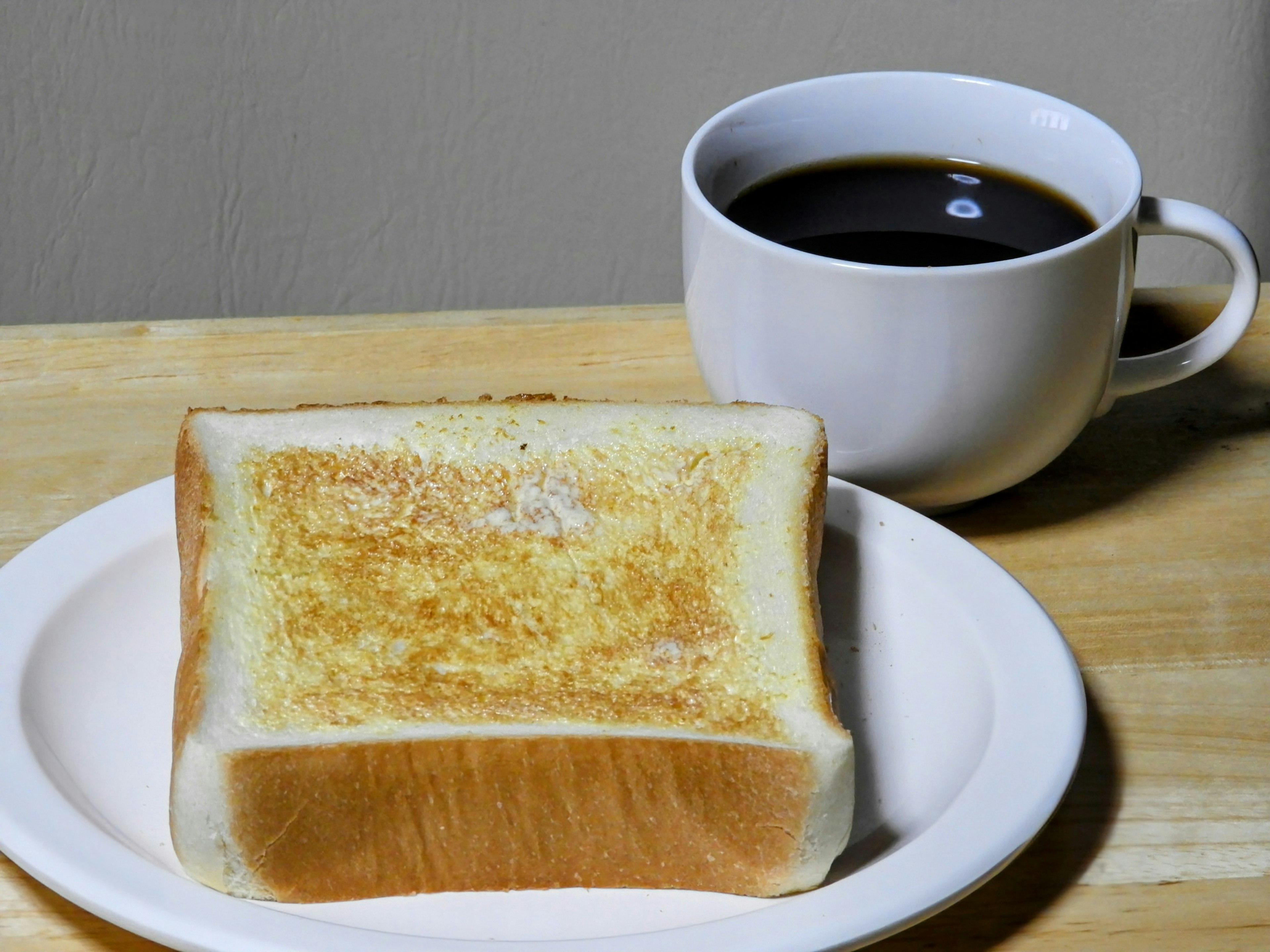 Desayuno simple con una rebanada de pan tostado y una taza de café