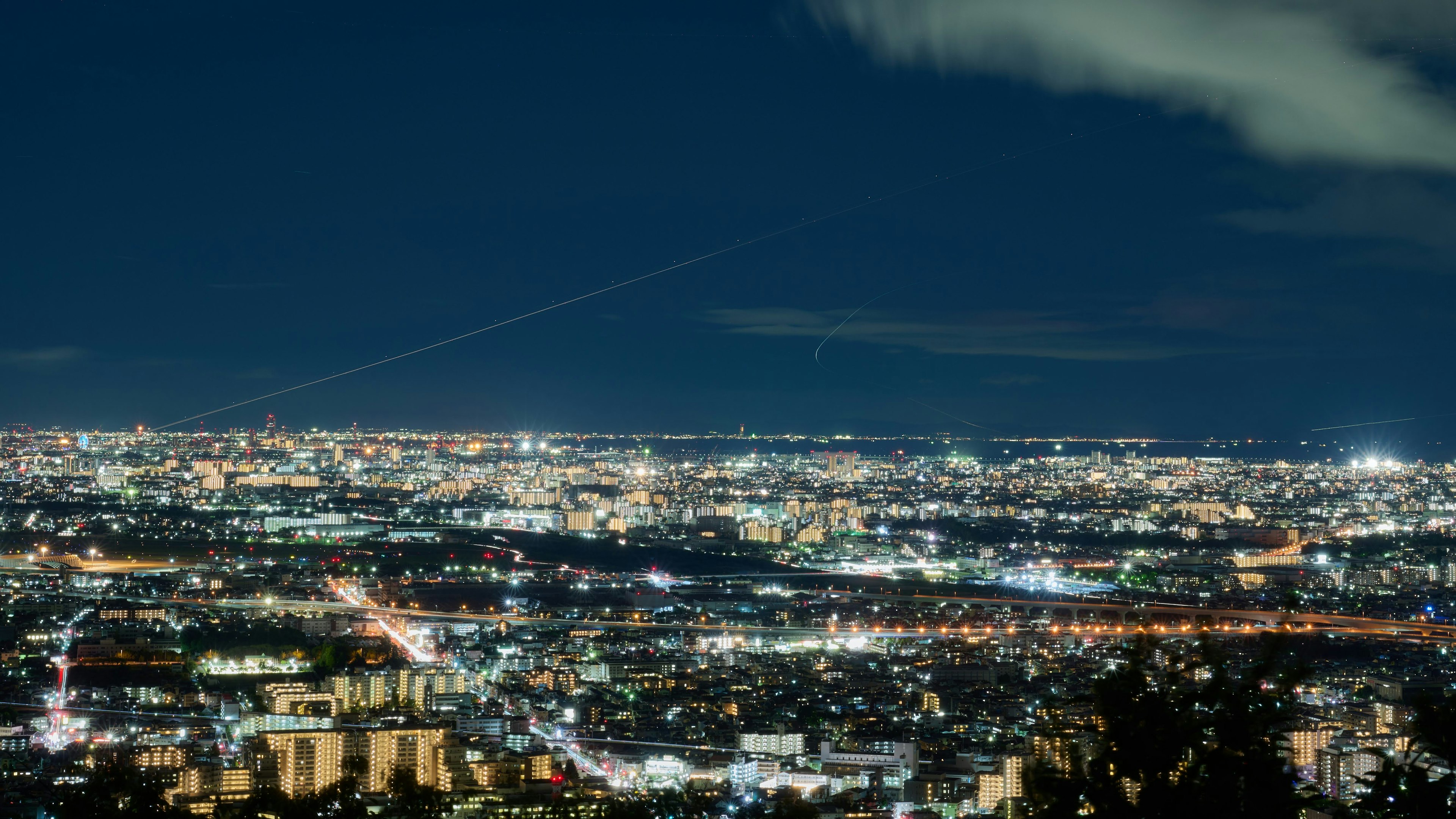 Paysage urbain nocturne avec des bâtiments lumineux et des routes illuminées