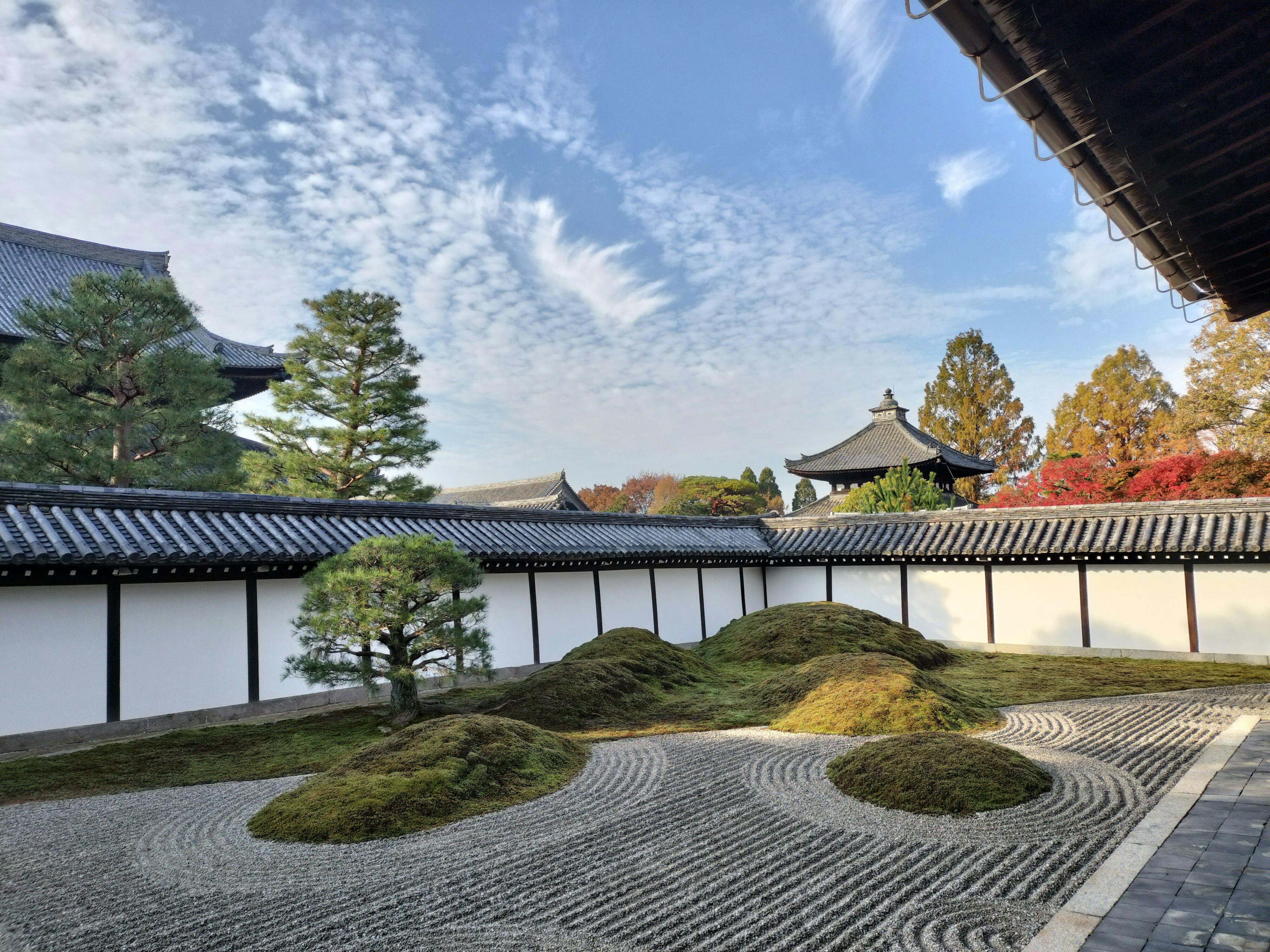 Schöne Aussicht auf einen japanischen Tempelgarten mit grünem Moos und gemustertem weißen Sand