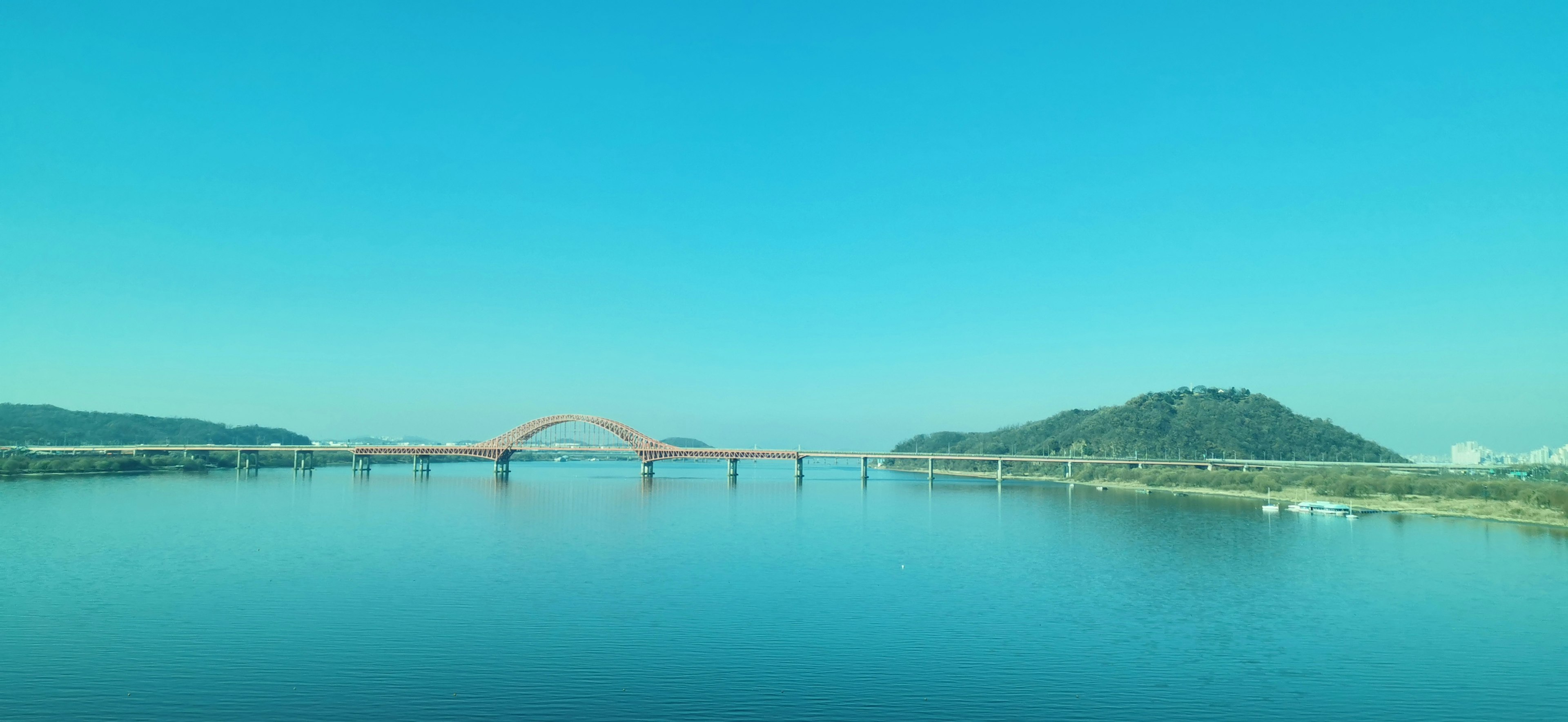 Malersicher Blick auf einen Fluss und eine Brücke unter einem blauen Himmel