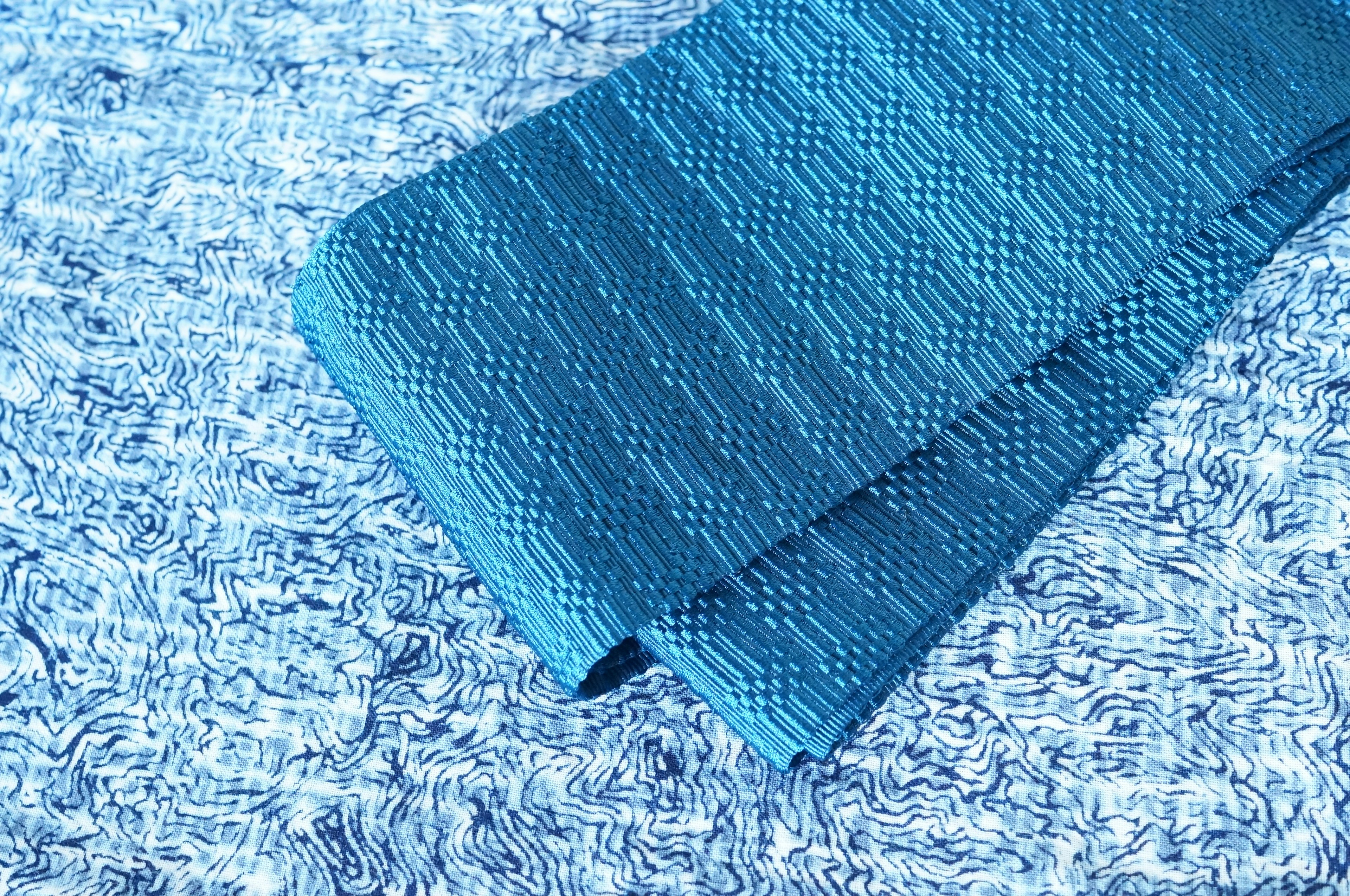 Blue textured fabric placed on top of another blue surface