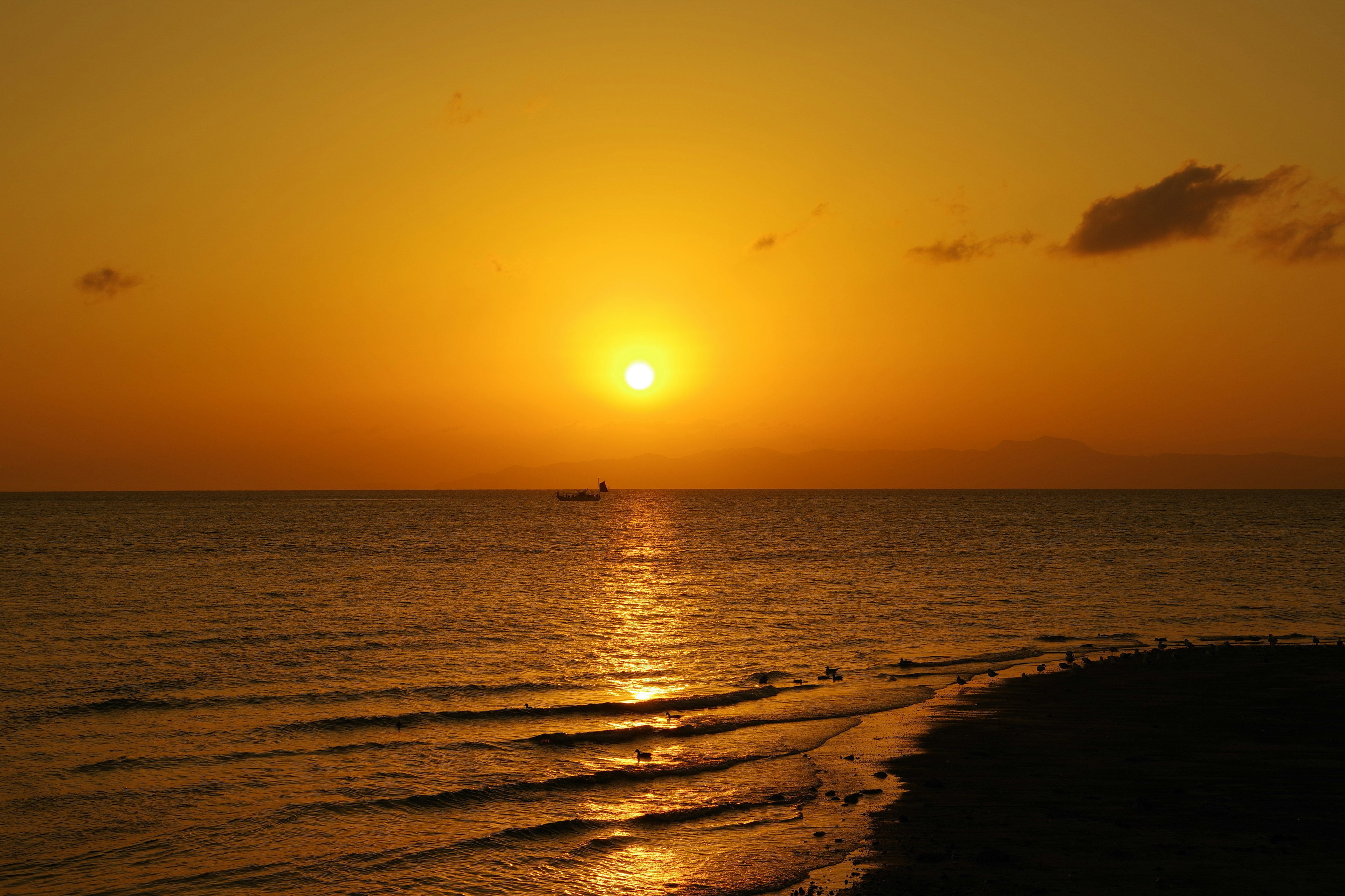 Paysage magnifique du coucher de soleil avec une lumière orange se reflétant sur la mer