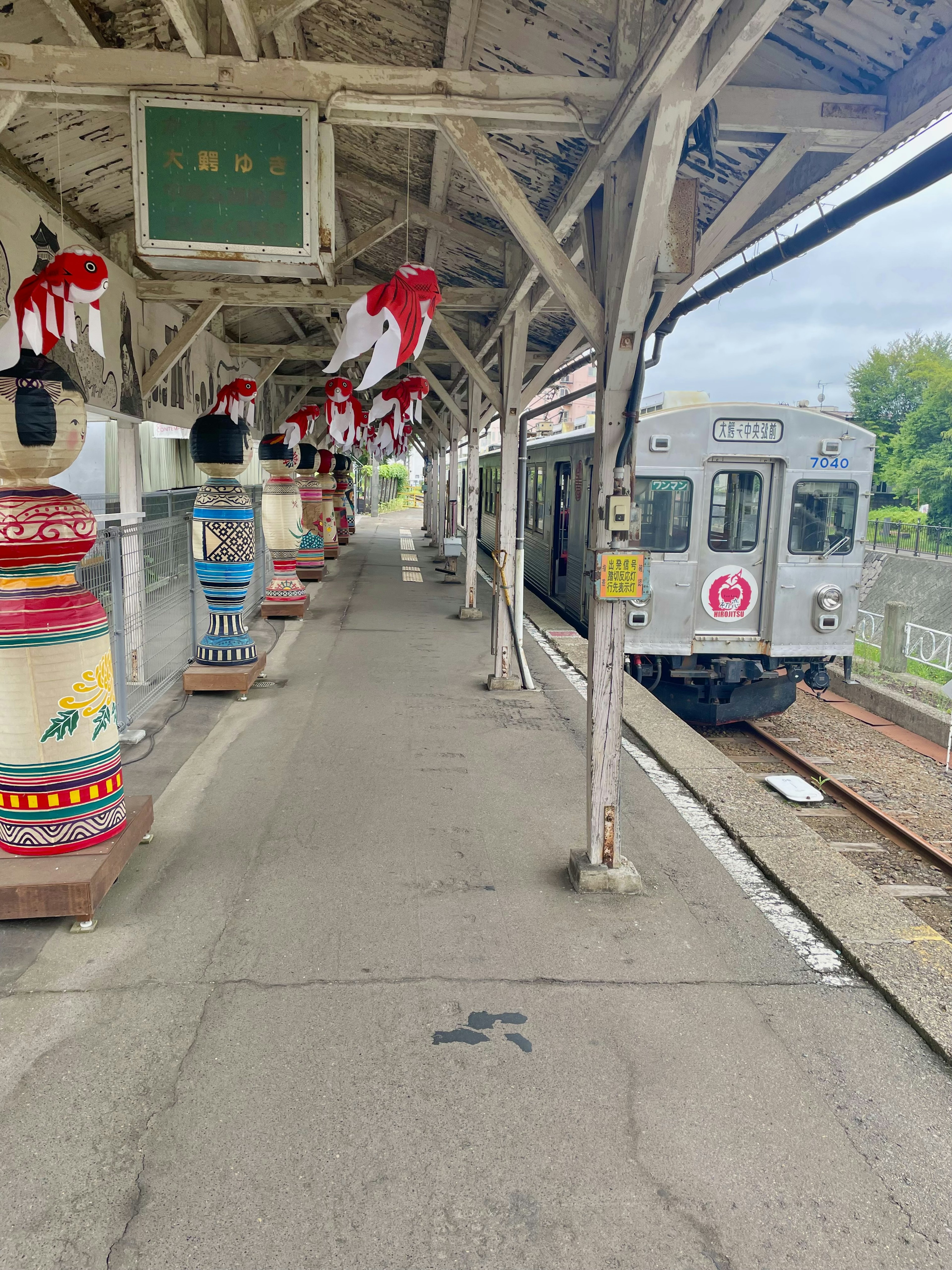 Silver train at a platform with colorful pillars and decorative elements