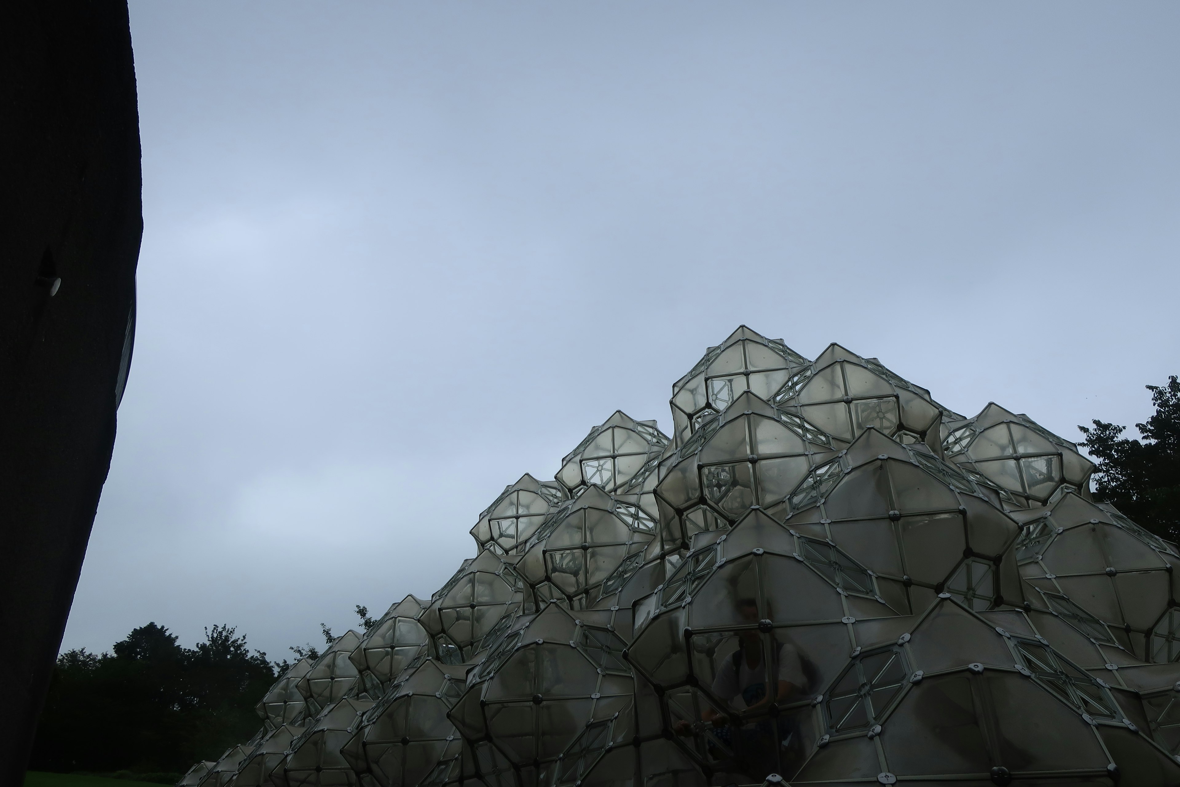 Stapel aus transparenten Kuppeln vor einem bewölkten Himmel