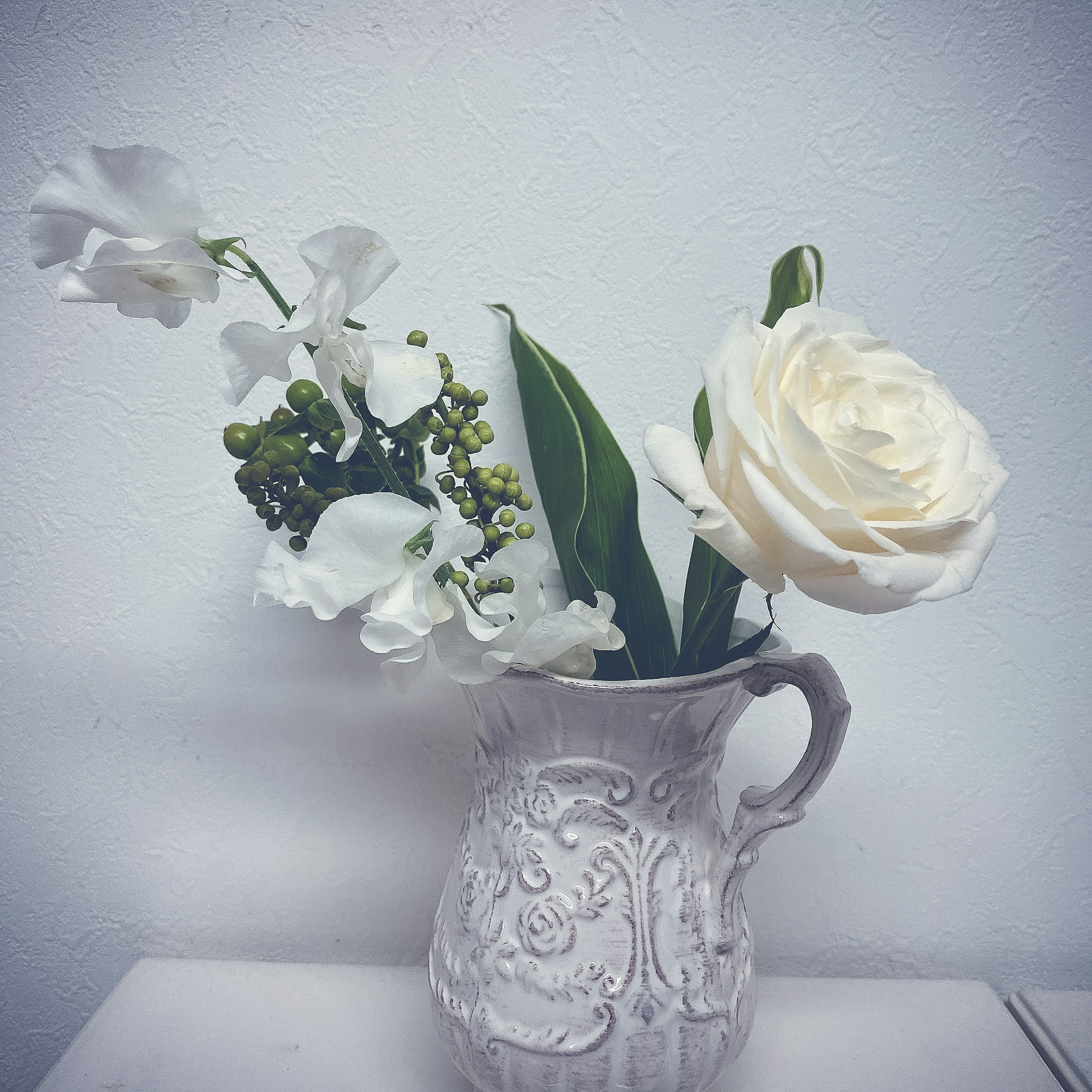 Vaso decorativo con rosa blanca y guisantes dulces