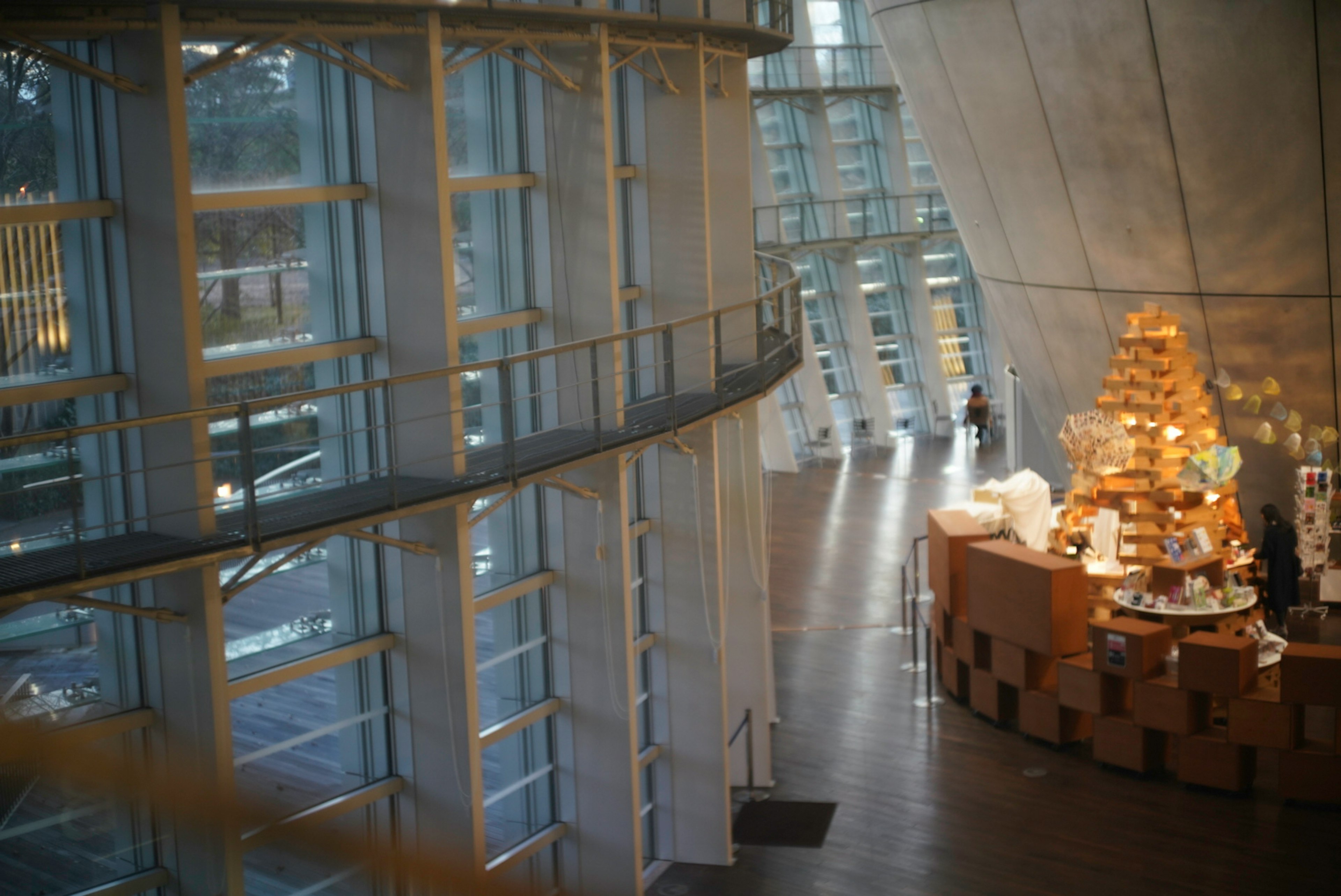 Interior de un edificio moderno con estructura de vidrio y hormigón y un área de café bien iluminada