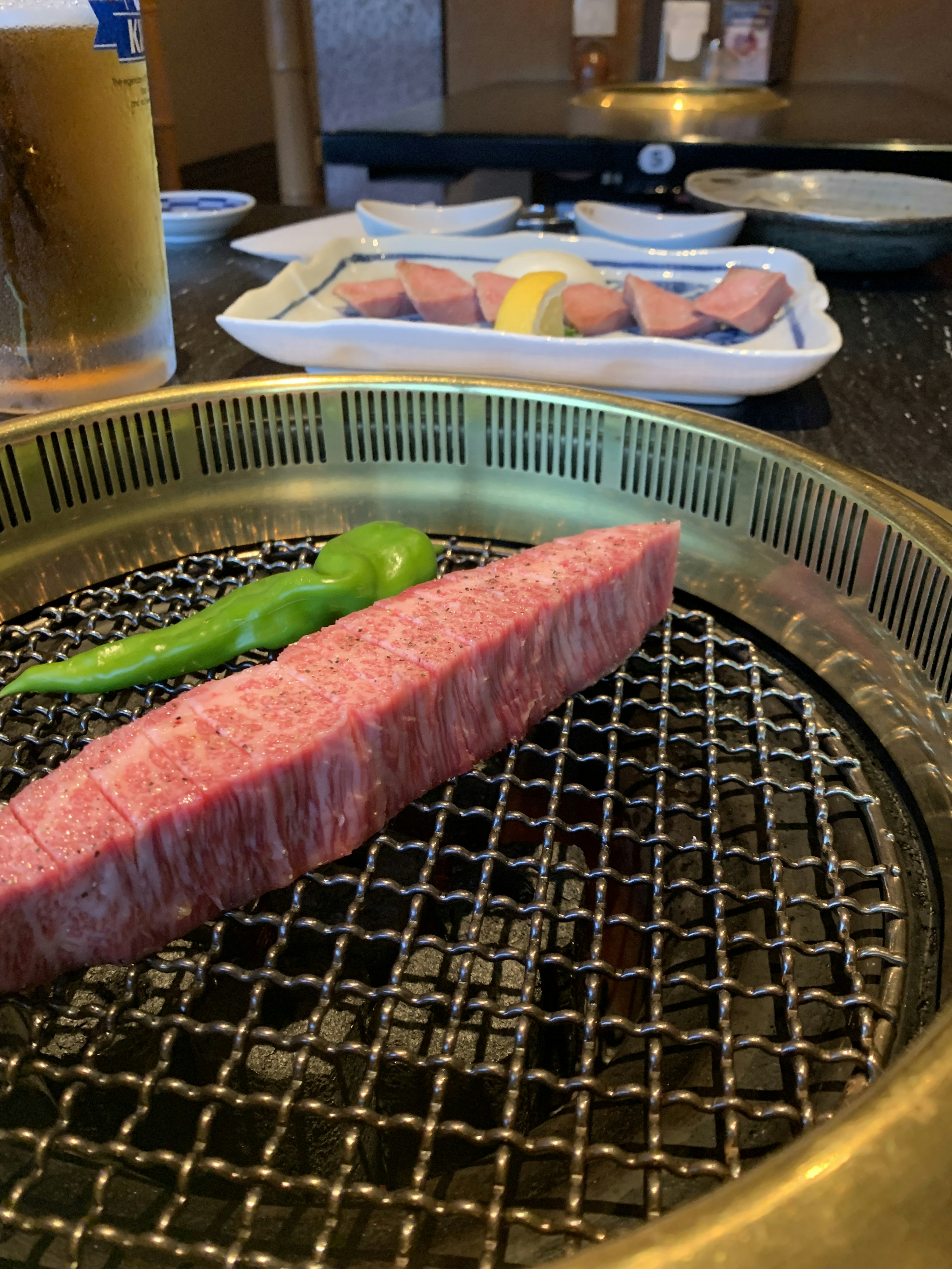 Eine schöne Fleischscheibe auf einem Grill mit einer grünen Chili