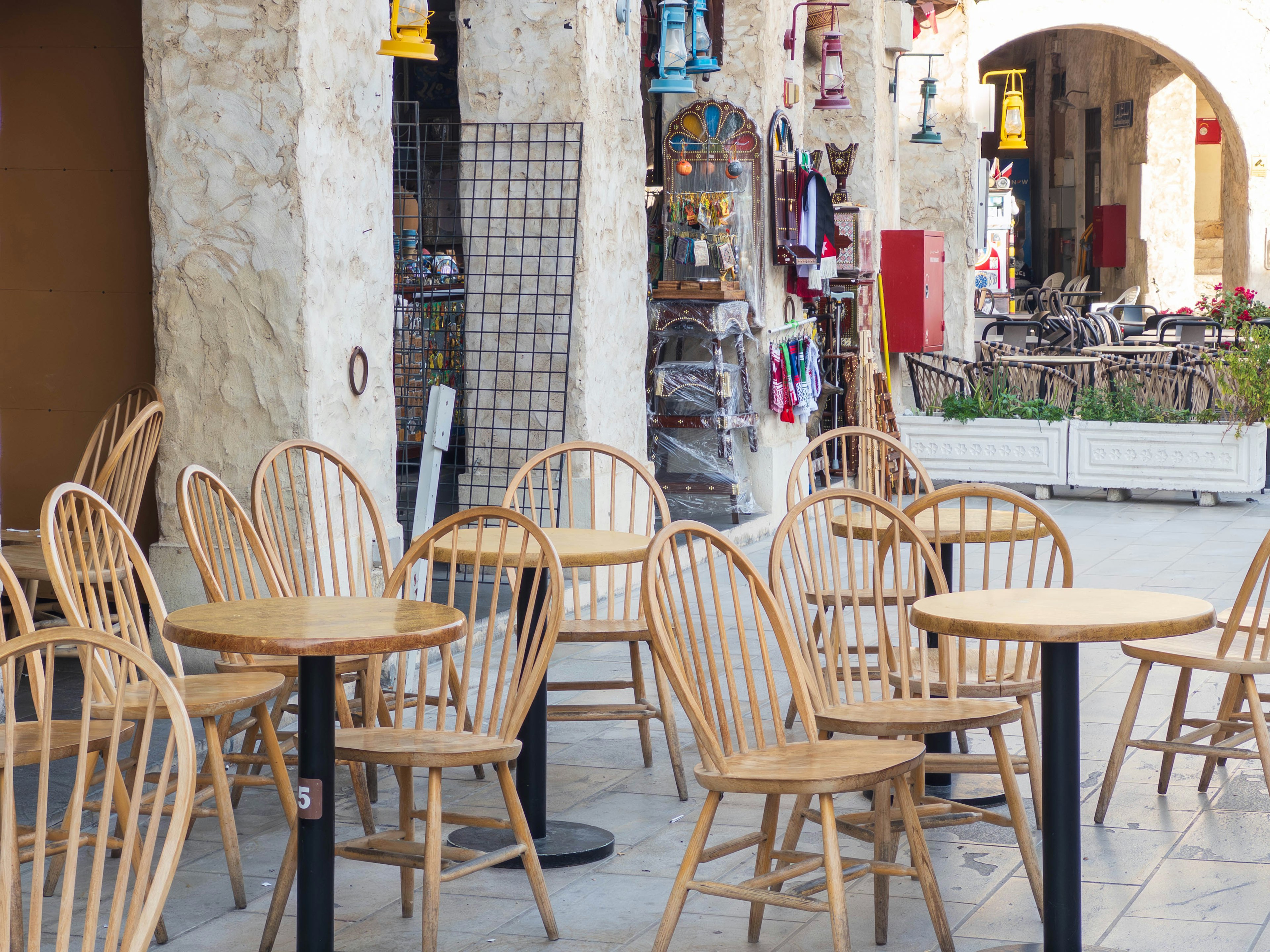 Sillas y mesas de madera dispuestas afuera de un café