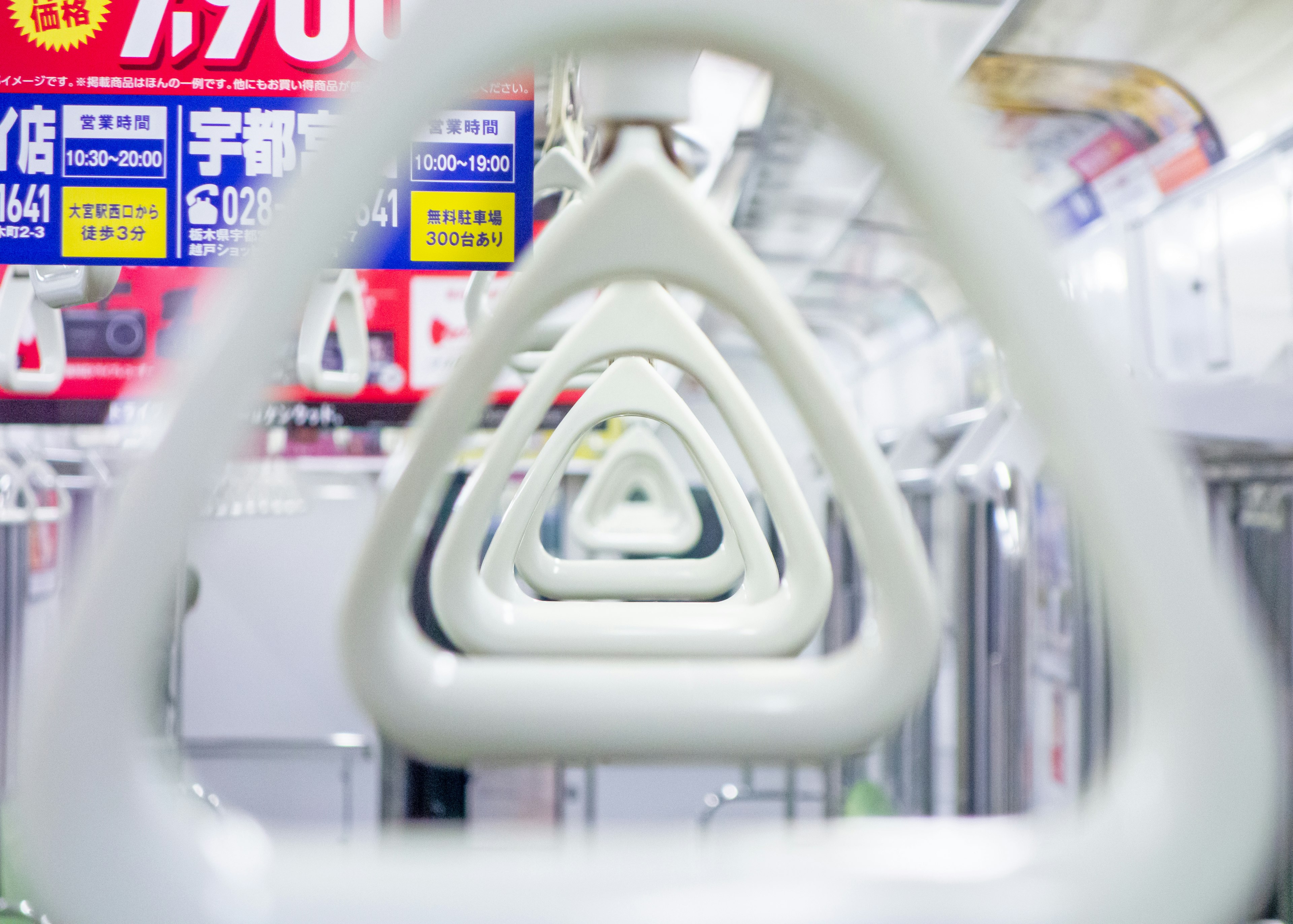 Maniglie bianche triangolari in un treno della metropolitana che creano un effetto prospettico