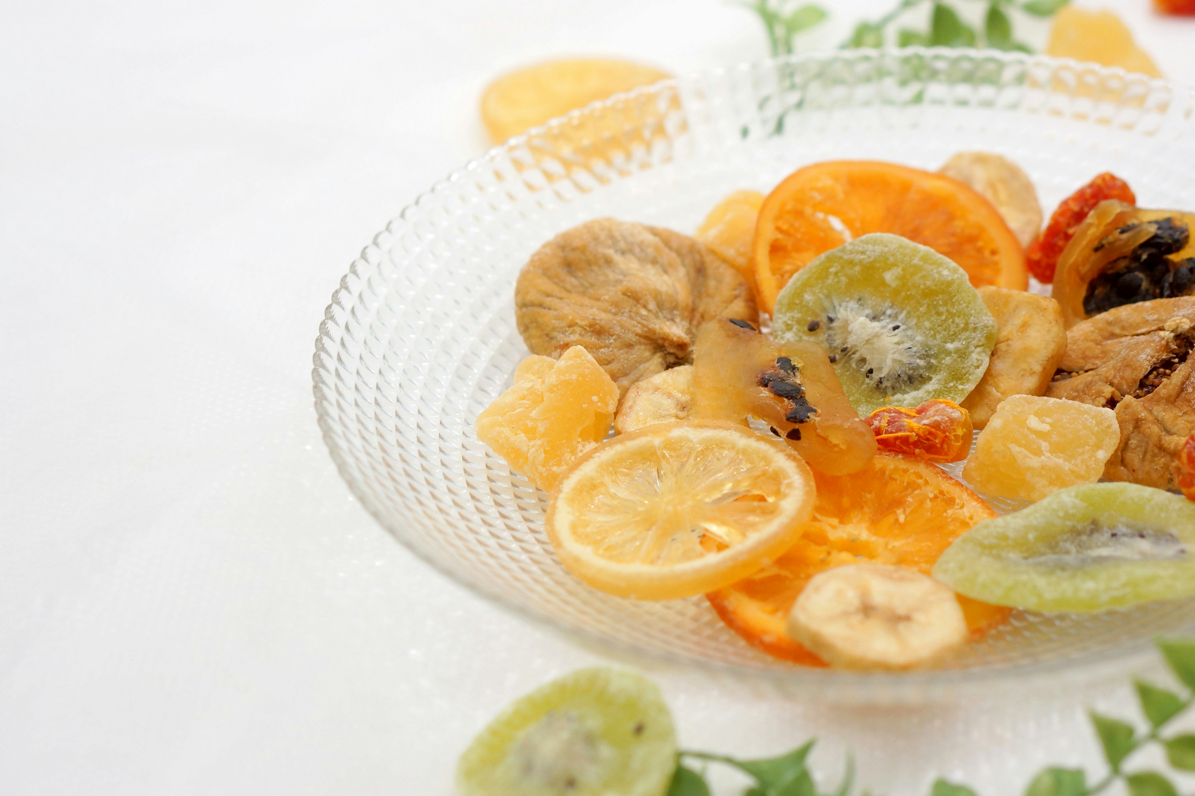 A glass bowl filled with colorful dried fruits