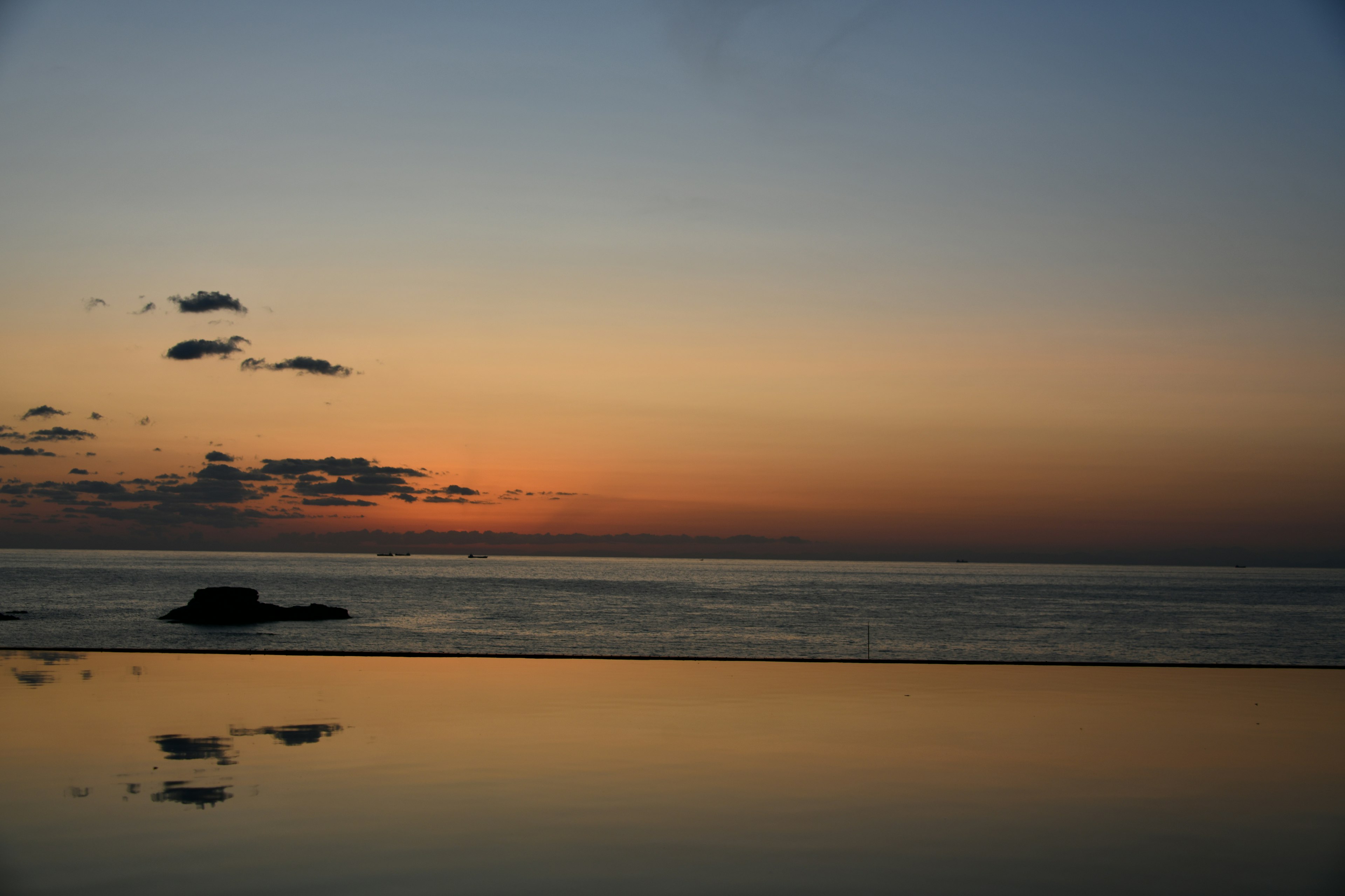 穏やかな海と夕焼けの空が映る風景