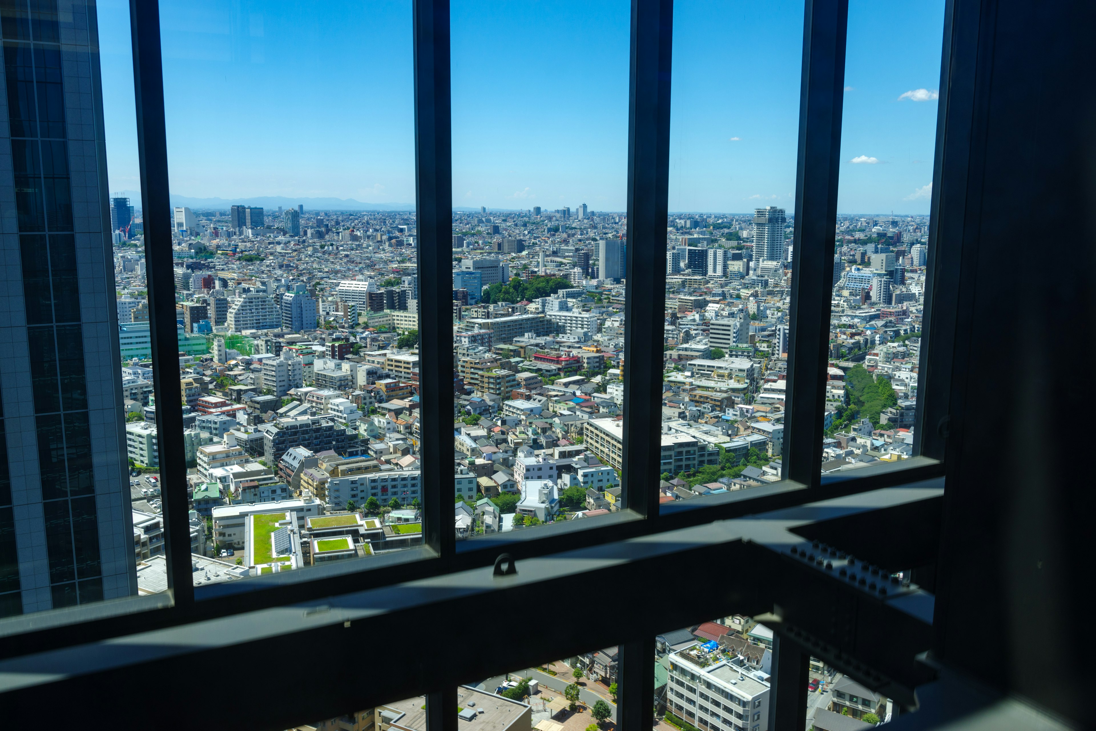 Pemandangan Tokyo dari jendela gedung pencakar langit Lanskap kota terlihat melalui bingkai jendela