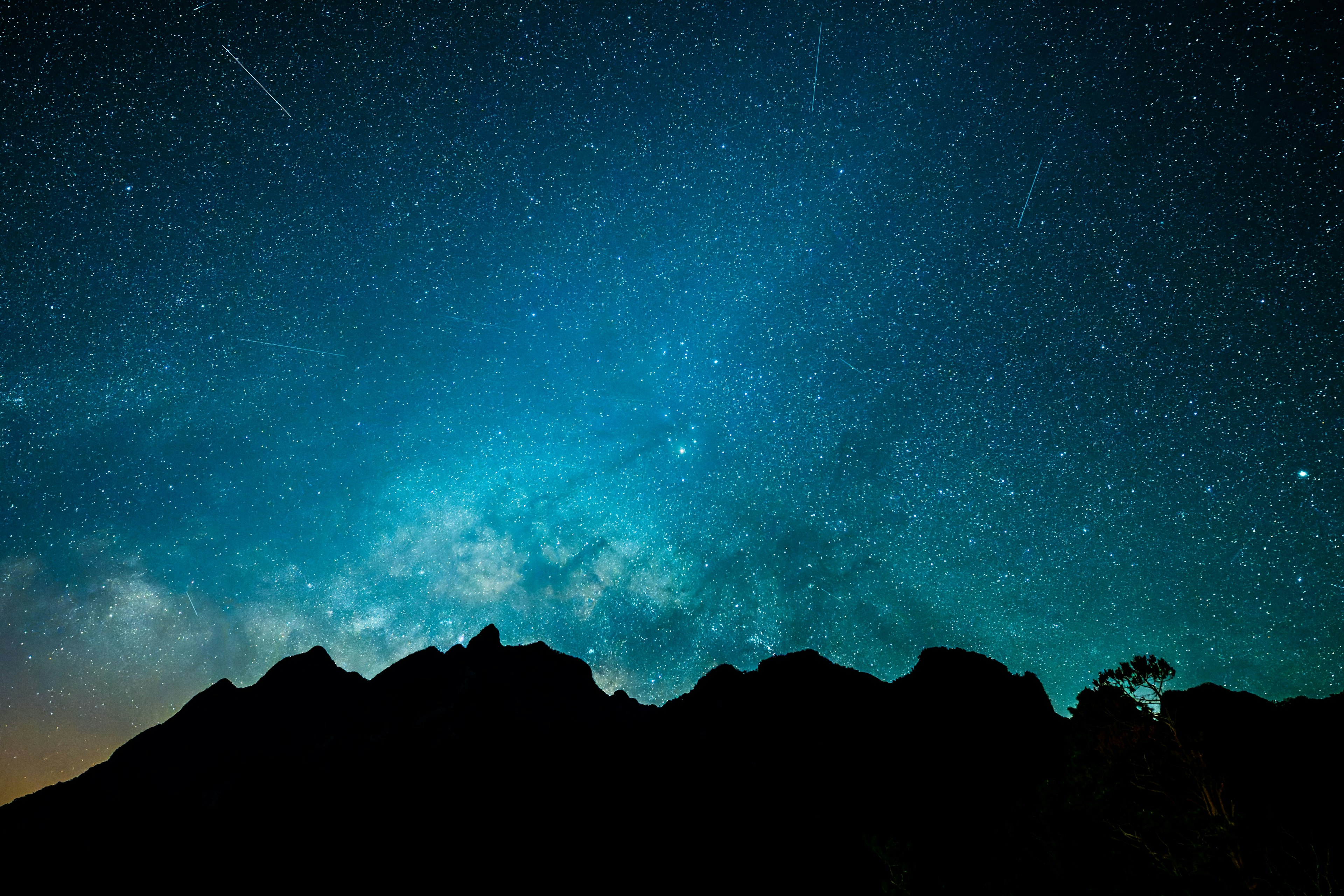 Impresionante paisaje nocturno con cielo estrellado y silueta de montañas