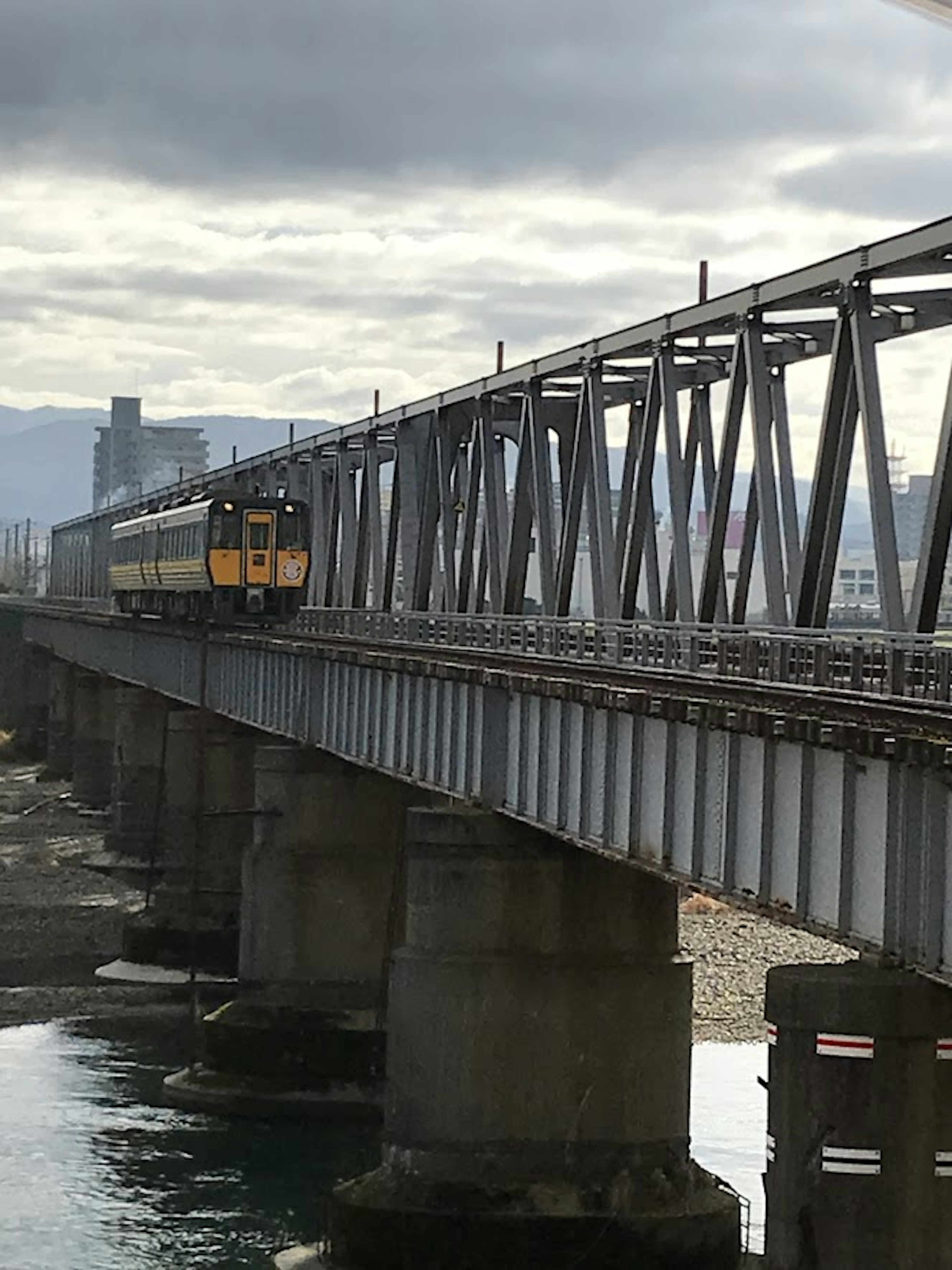 Treno che attraversa un ponte in acciaio su un fiume