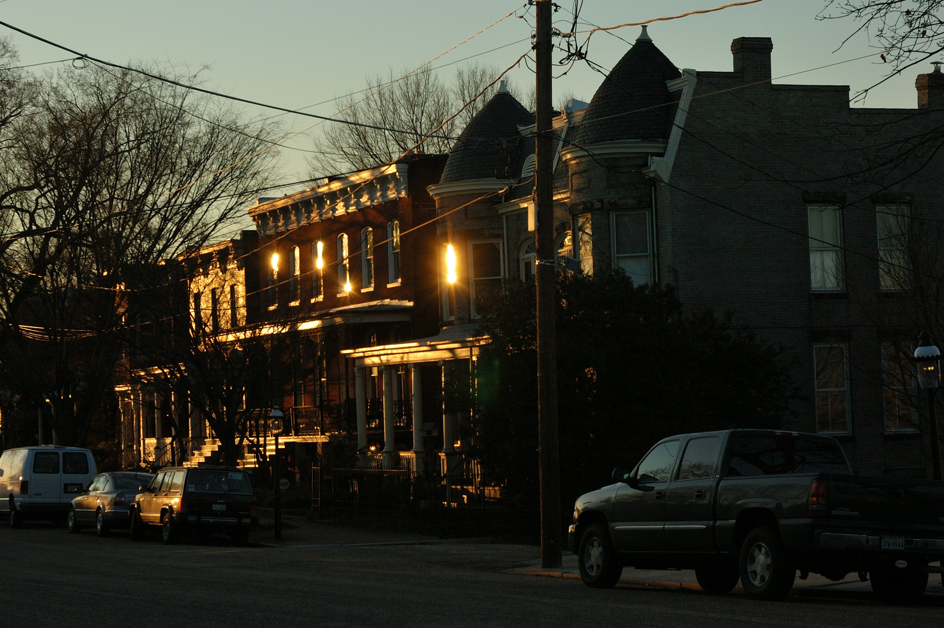 Twilight street scene with glowing lights from houses in a residential area