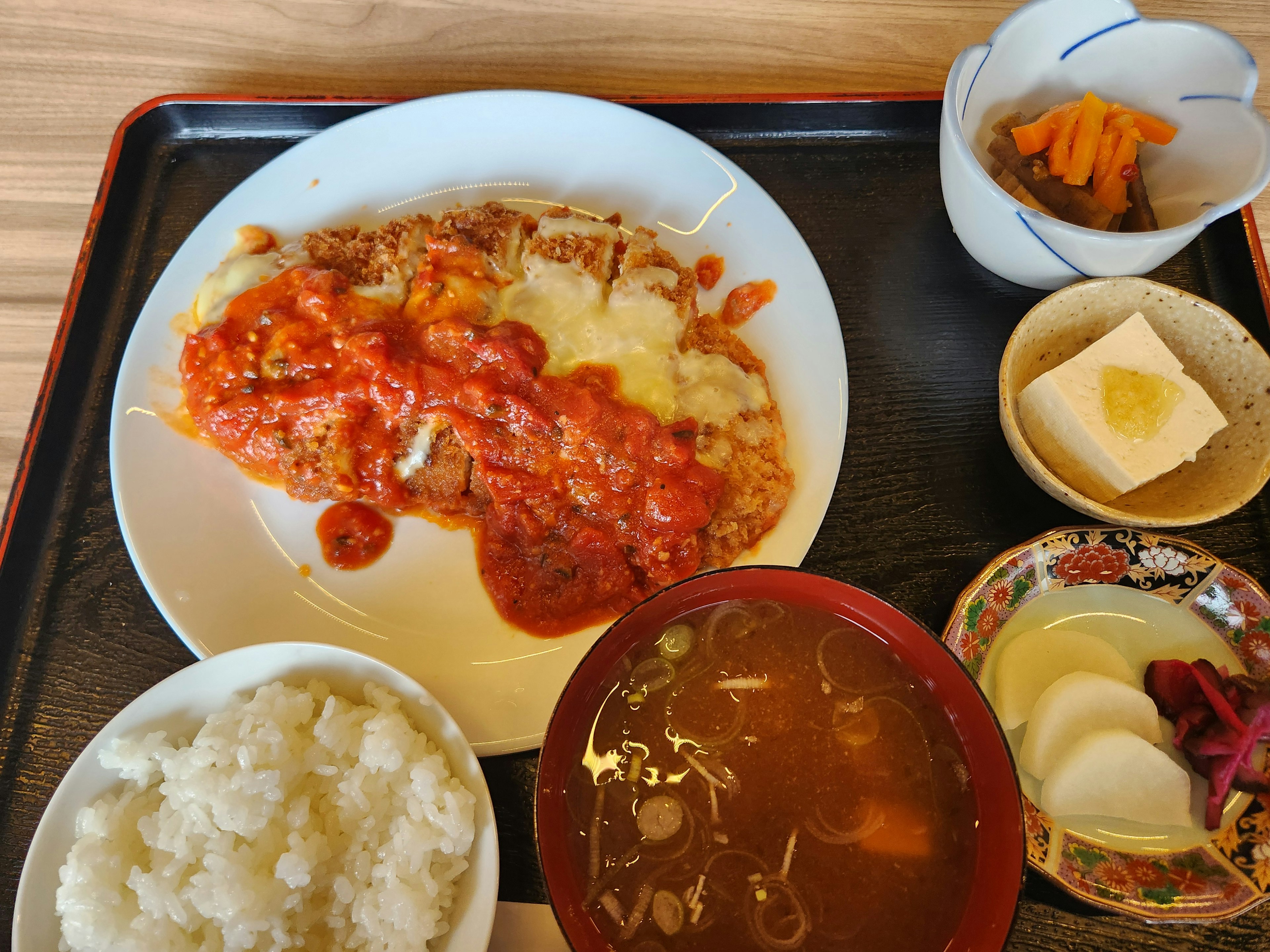 Hähnchen-Katsu mit Tomatensauce serviert mit Reis und Beilagen