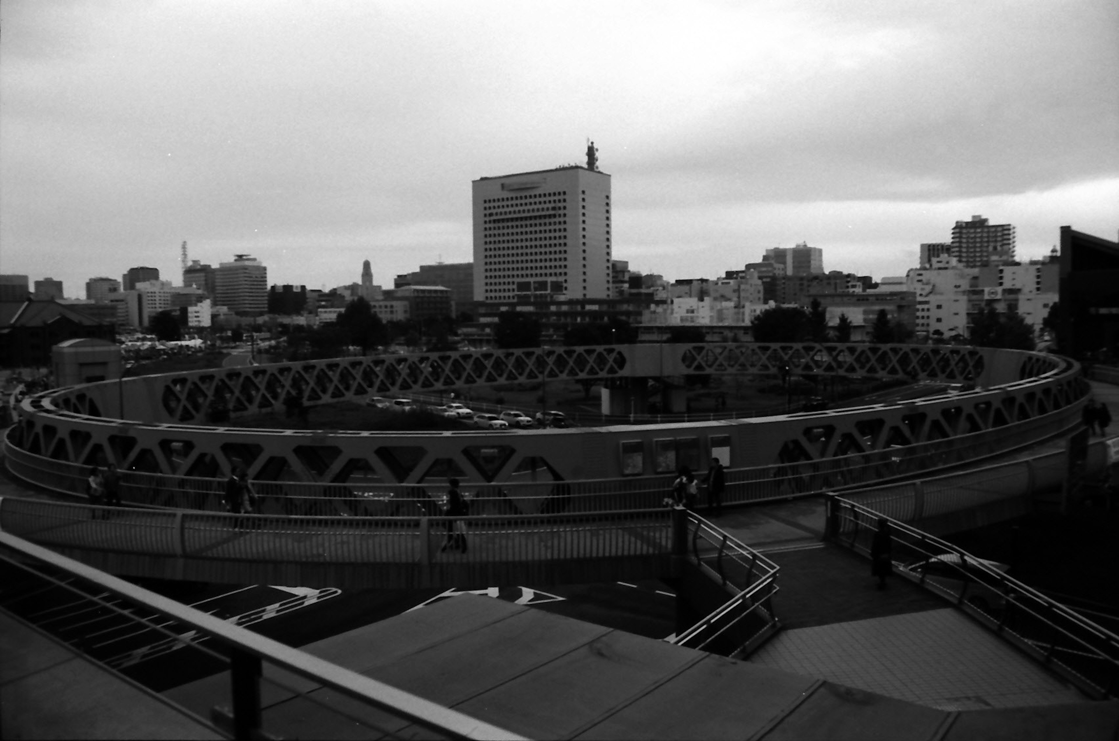 Image en noir et blanc présentant un paysage urbain avec un bâtiment circulaire