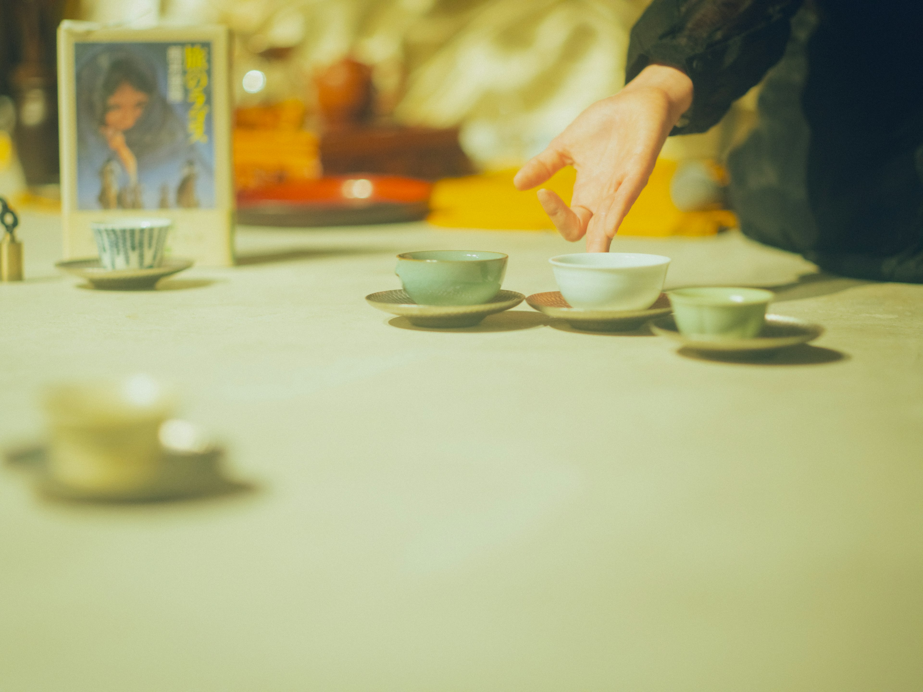 Main atteignant des tasses de thé sur une table