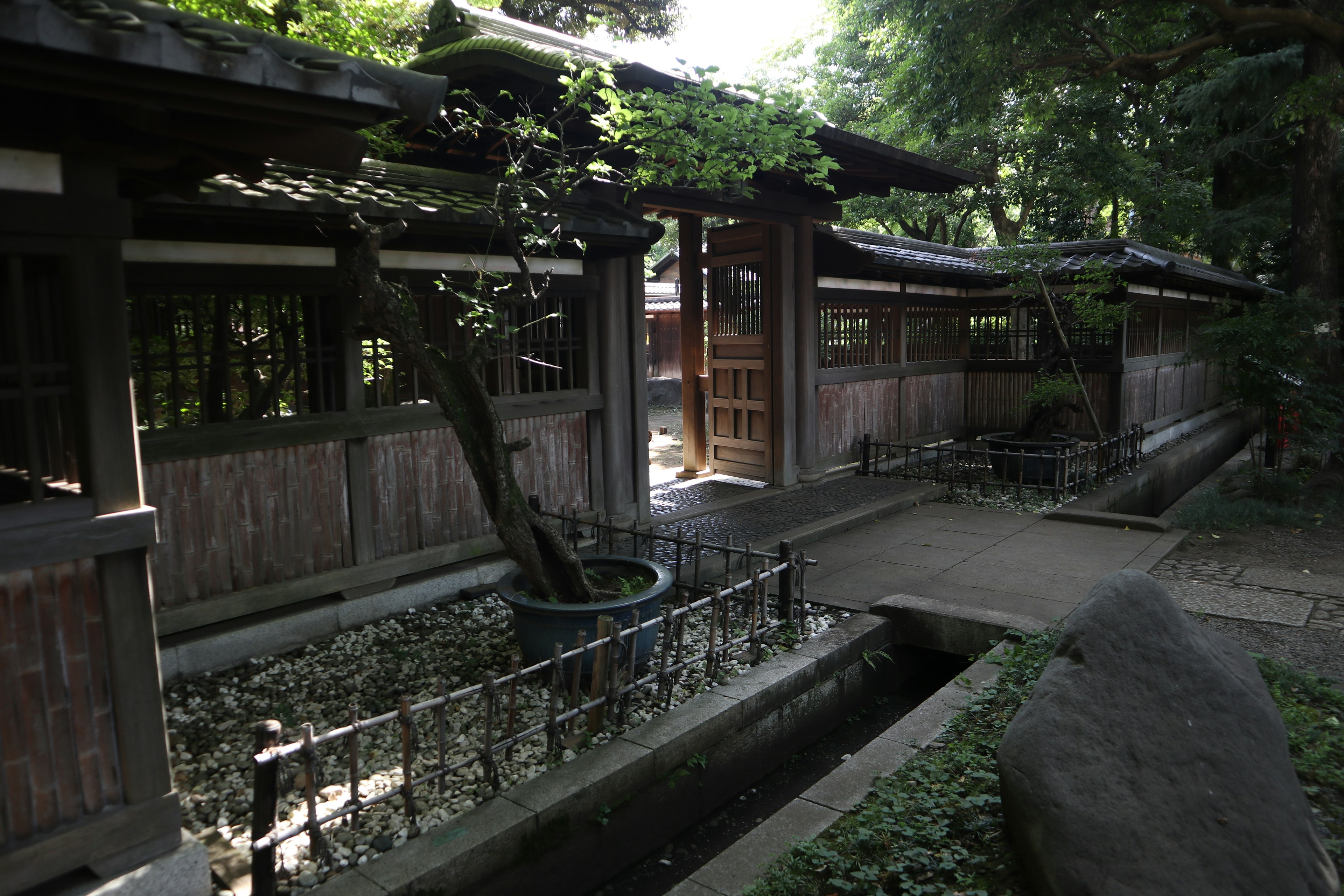 Serene Japanese garden pathway with wooden structures and lush greenery