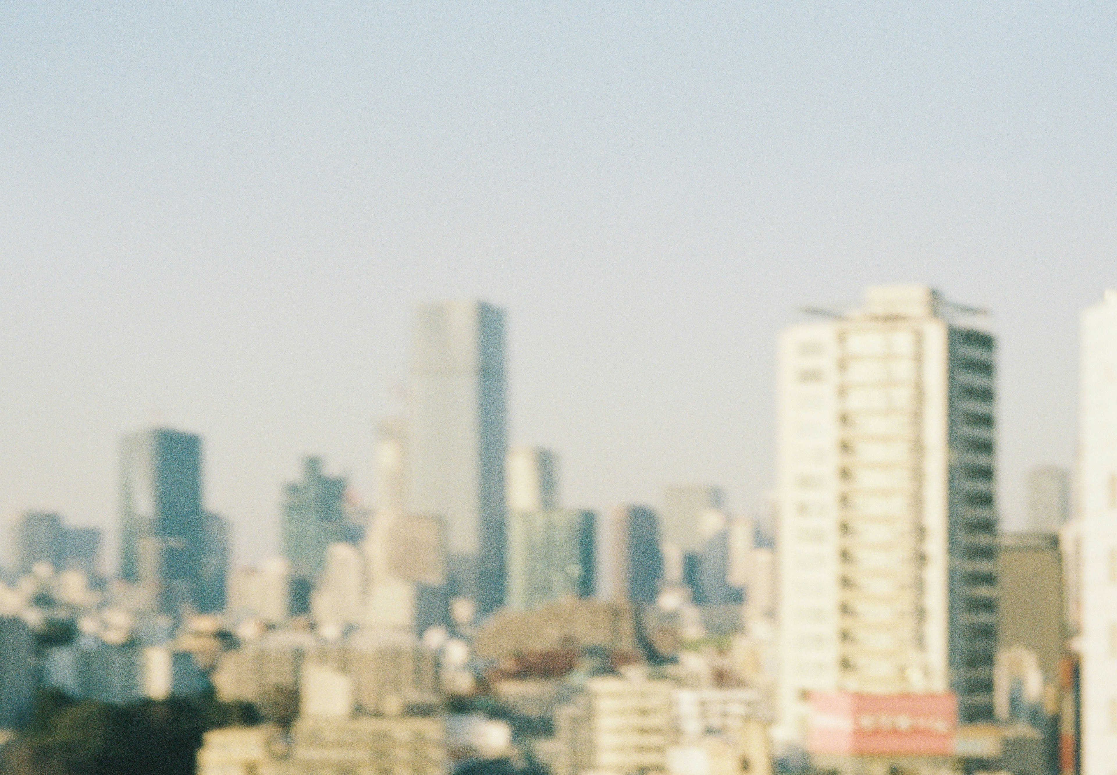 Verschwommenes Bild der Stadtlandschaft von Tokio mit Wolkenkratzern und blauem Himmel