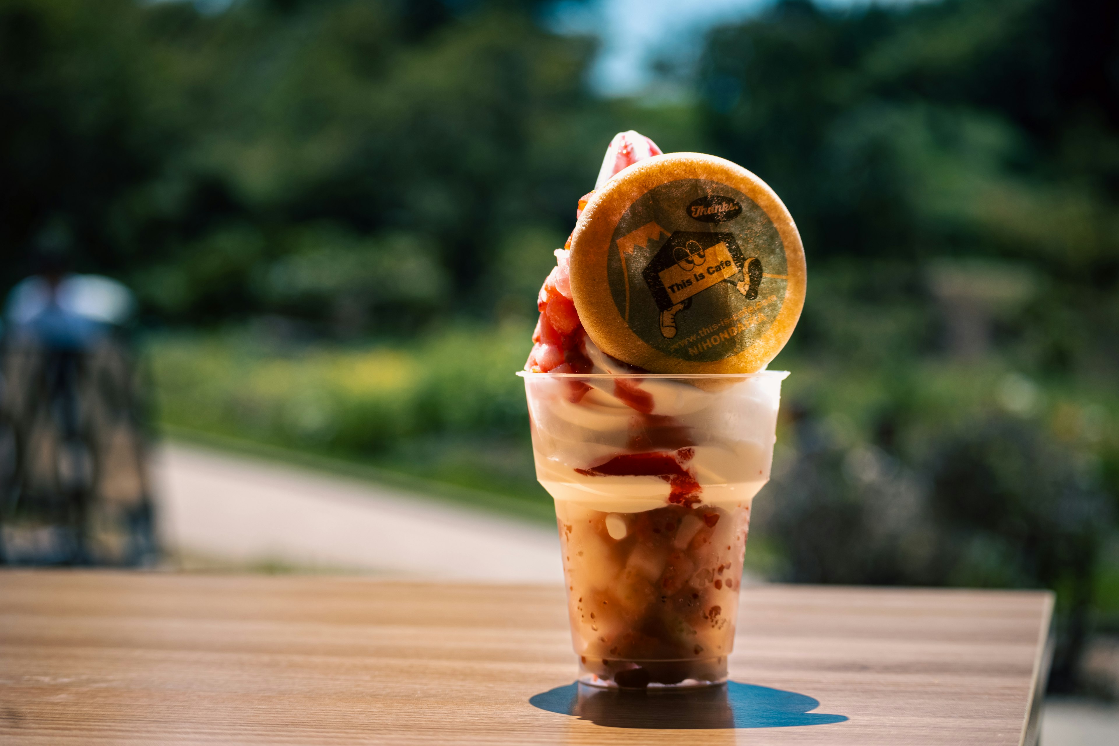 Dessert avec de la glace dans un gobelet surmonté de sauce aux fraises