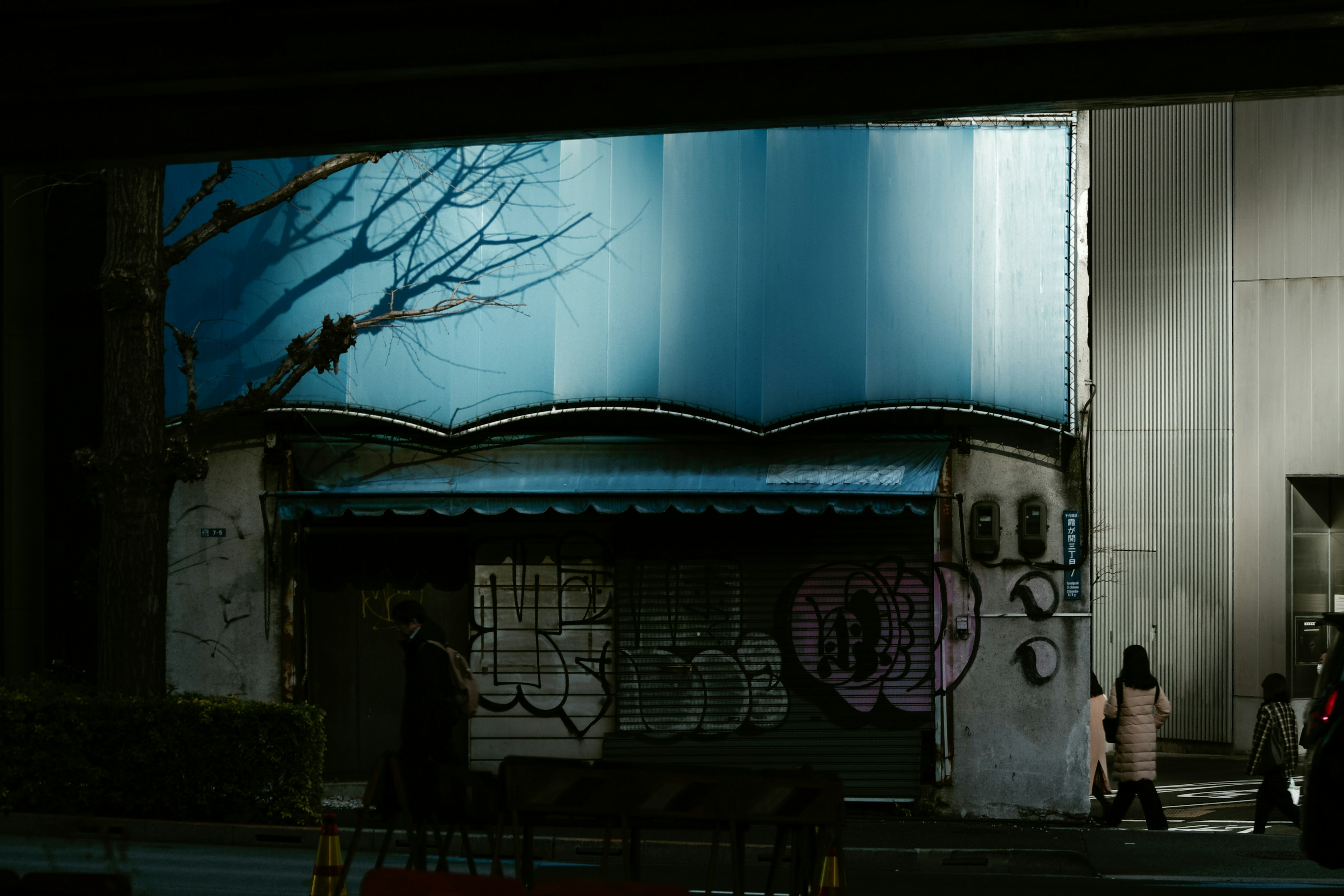 Altes Gebäude mit blauem Dach und Graffiti-Kunstschatten