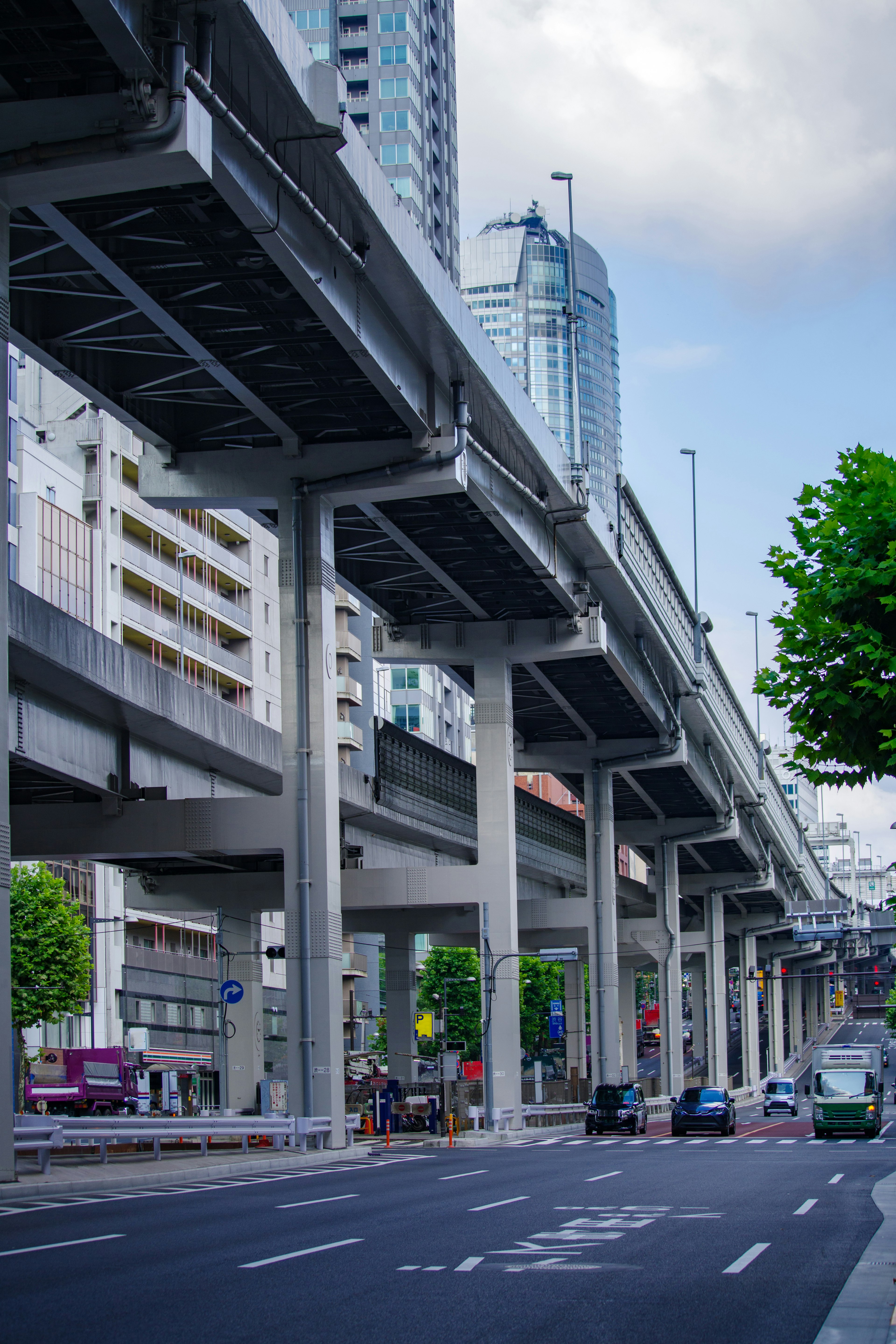 Jalan elevated perkotaan dengan gedung pencakar langit di latar belakang