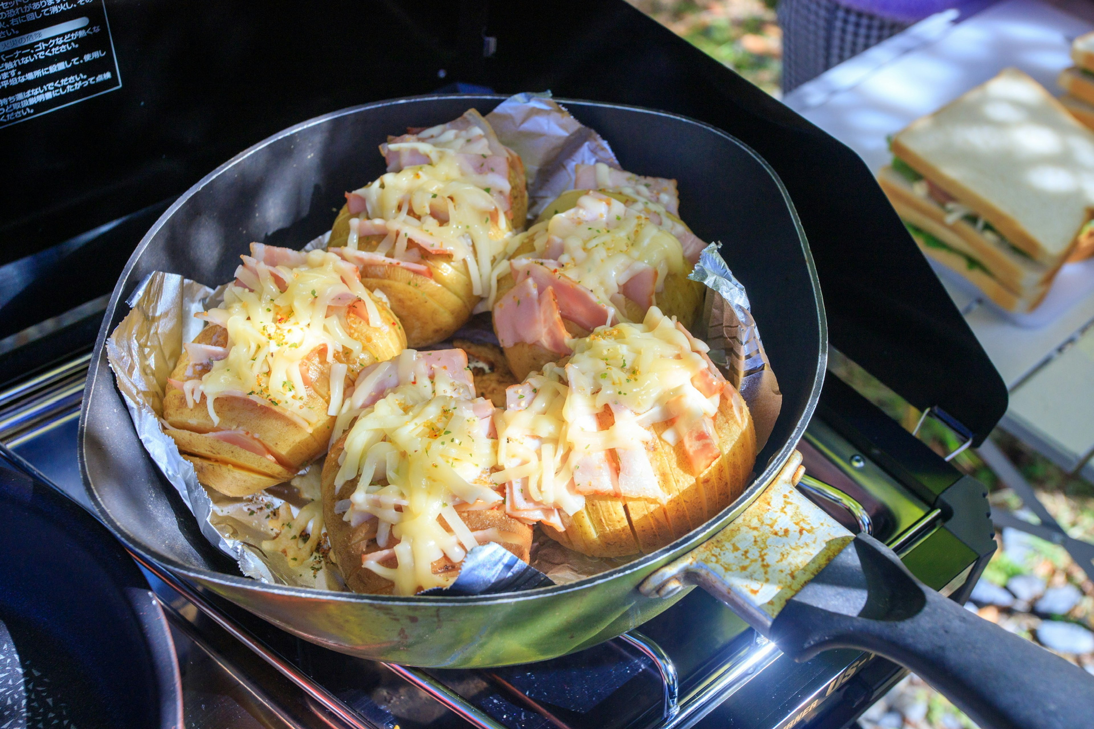 Baked bread rolls topped with cheese and ham cooking in a pan