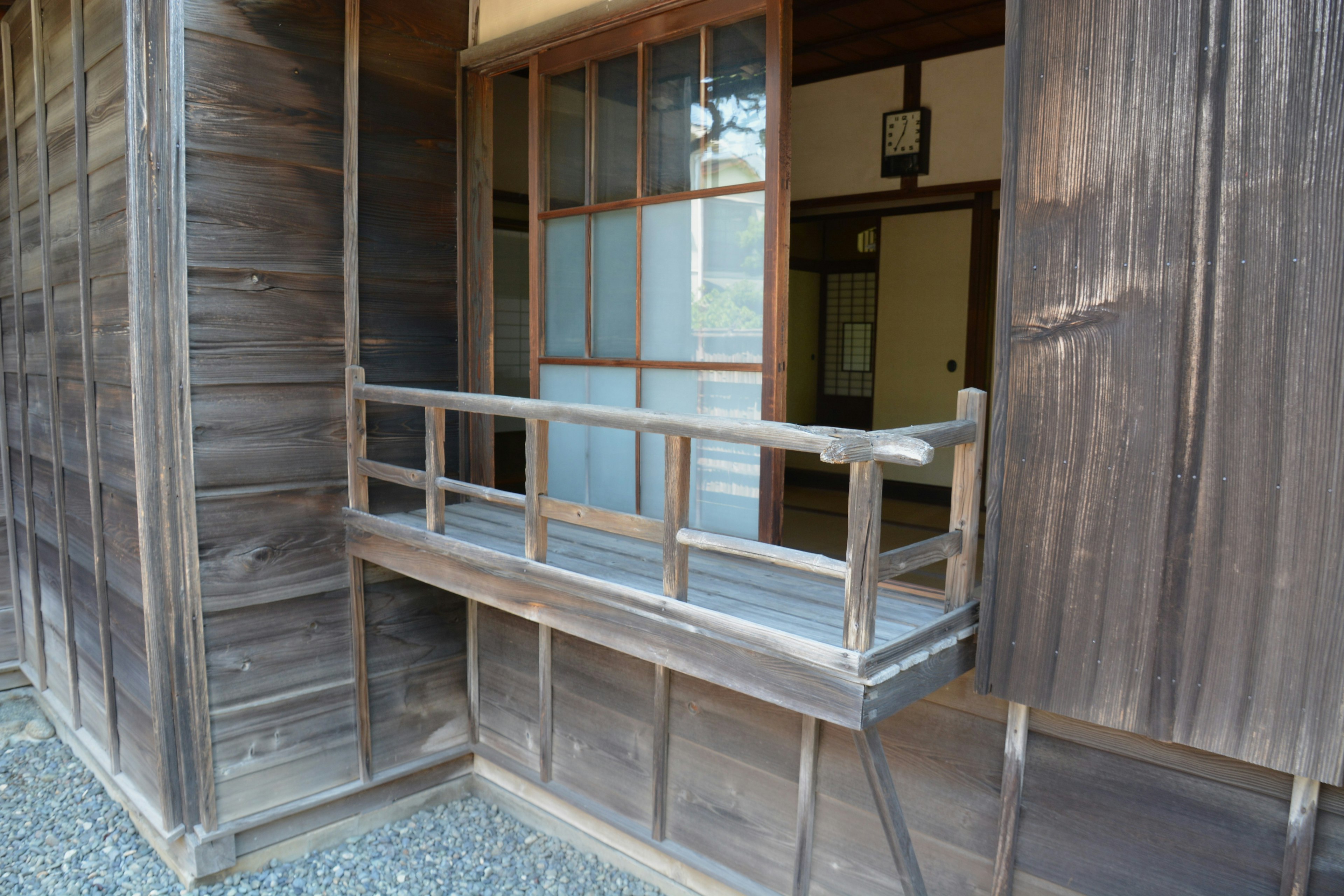 Image montrant une partie d'une maison japonaise traditionnelle avec une fenêtre et un balcon