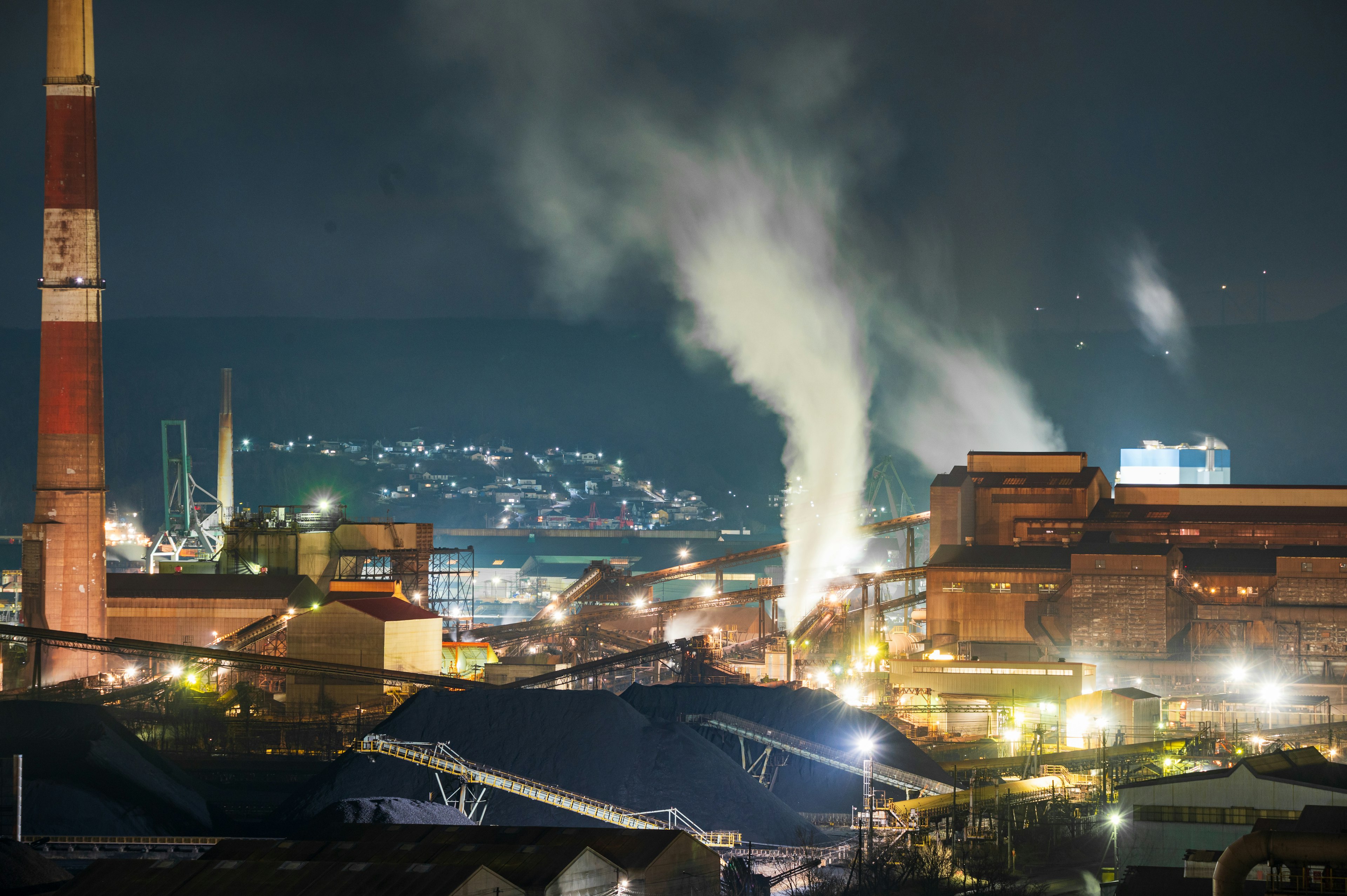 夜晚的工業區，煙囪和工廠冒出煙霧