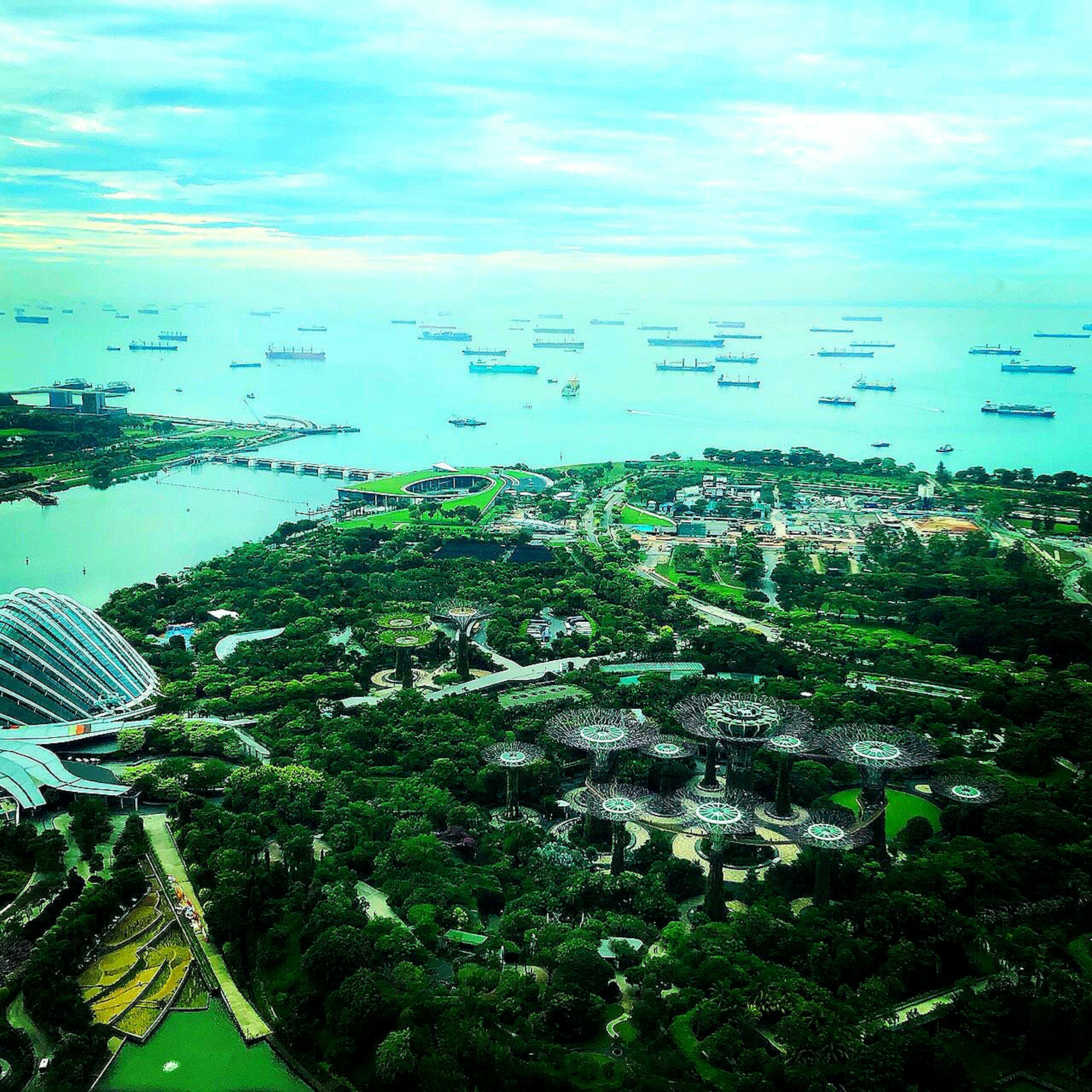 Vue aérienne de Singapour montrant la mer et les Jardins de la Baie avec des navires dans l'eau