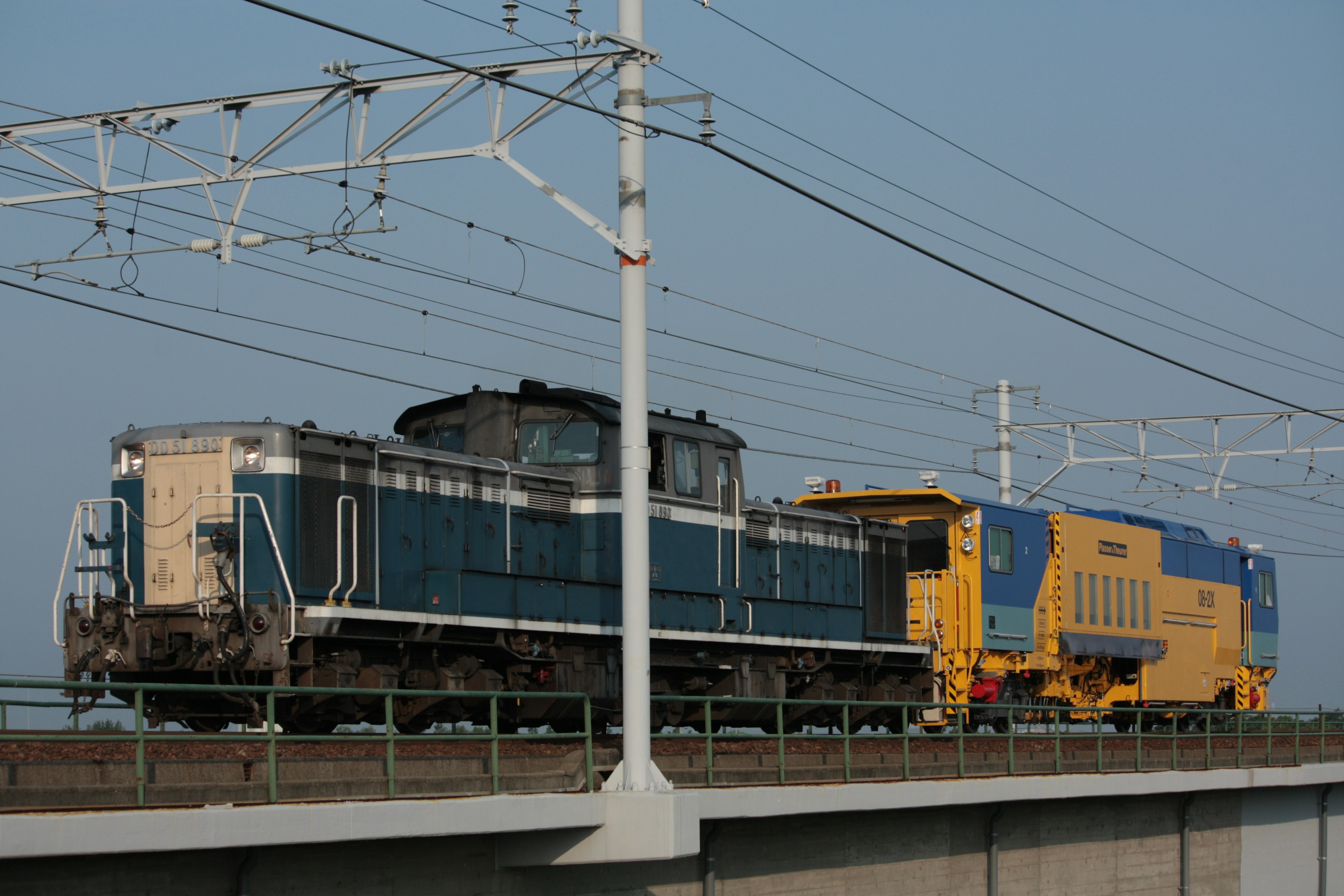 Tren azul y amarillo en vías elevadas