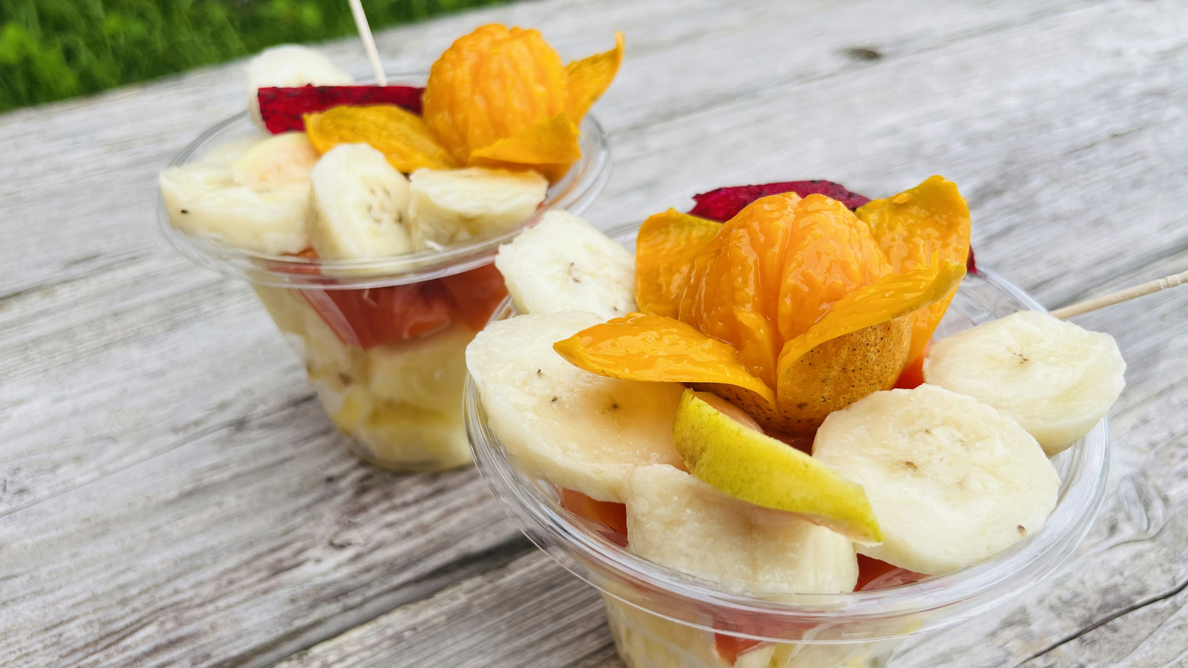 Coupes de fruits avec banane et tomate garnies de fruits dorés sur le dessus