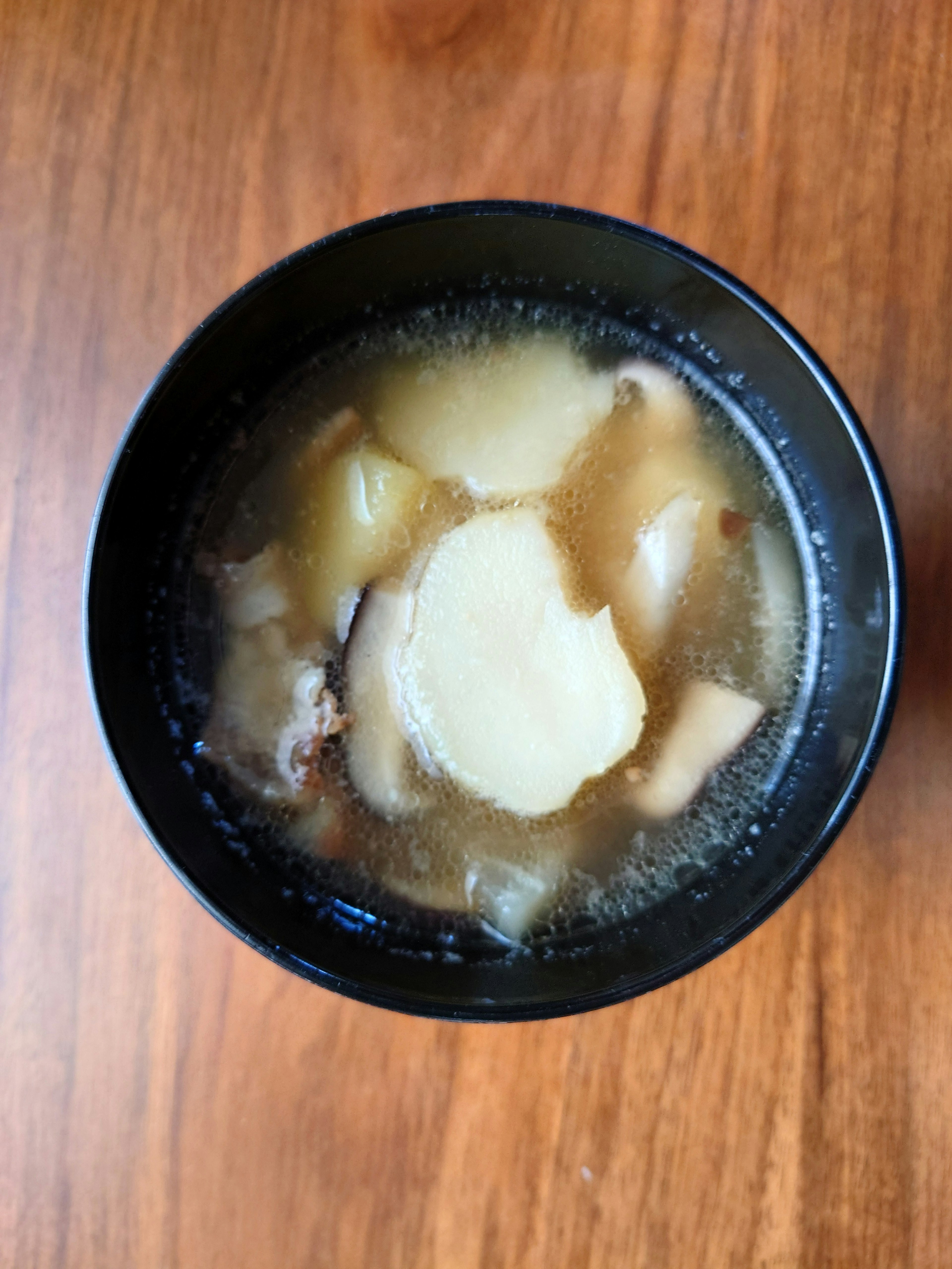 Vista dall'alto di zuppa in una ciotola nera con patate e carne